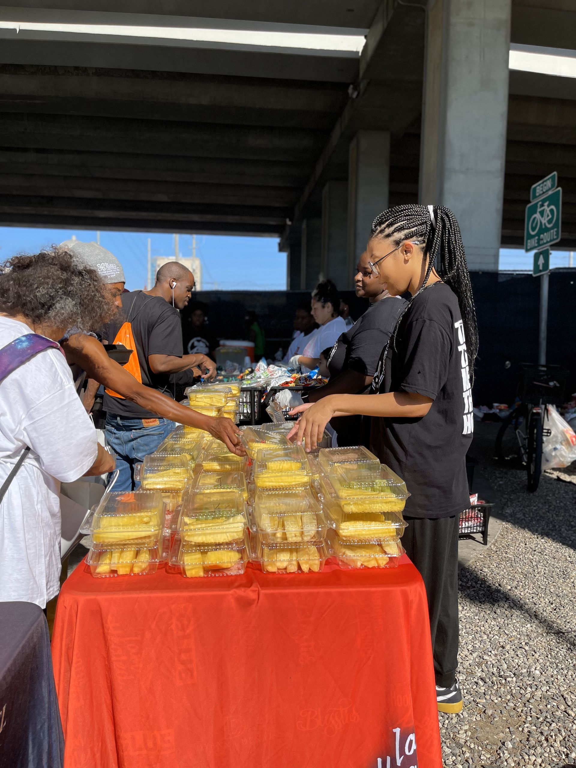 A group of people are standing around a table selling food.
