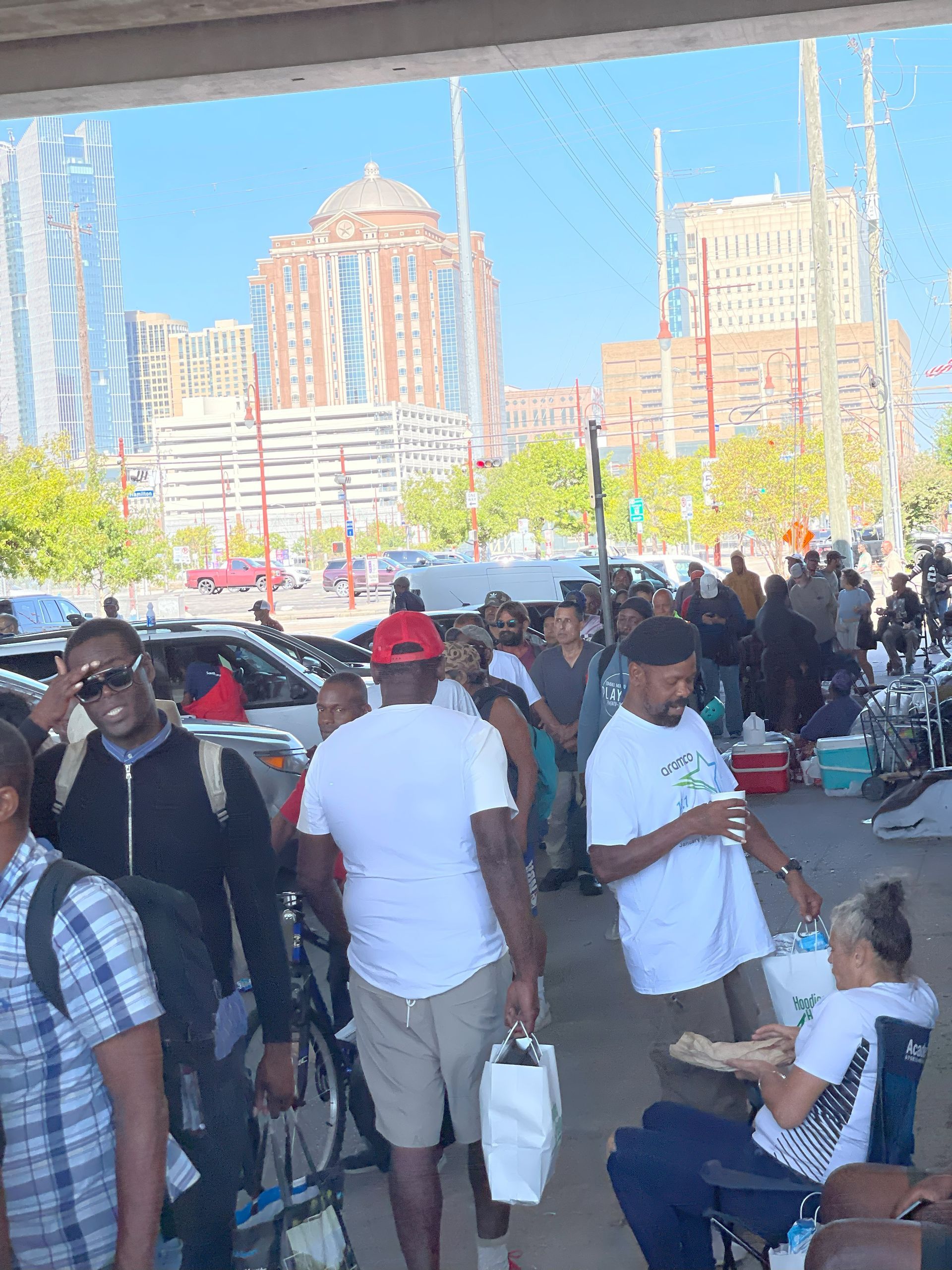 A group of people are standing in a parking lot.