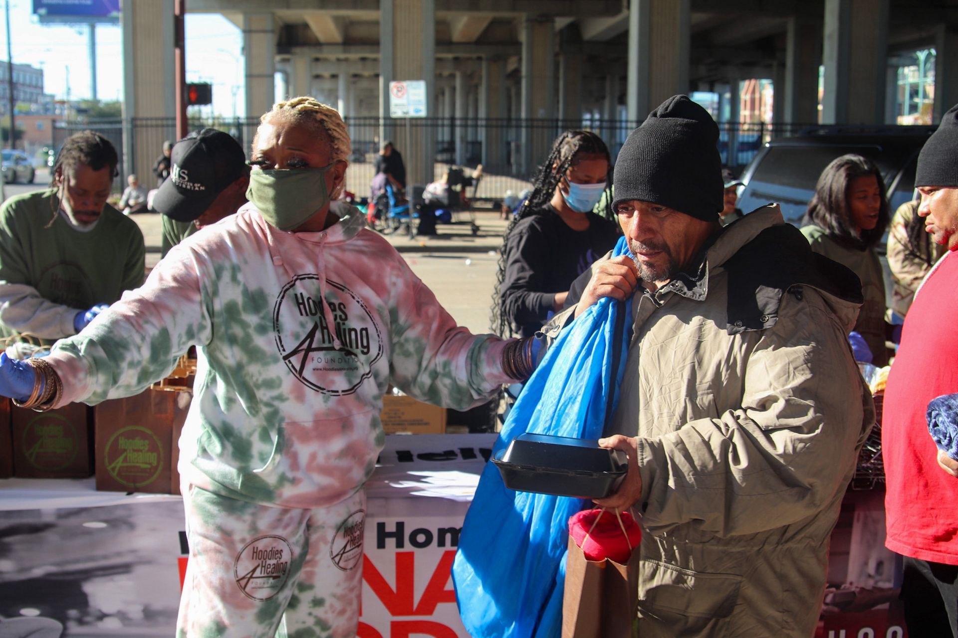 A group of people are standing around a table.