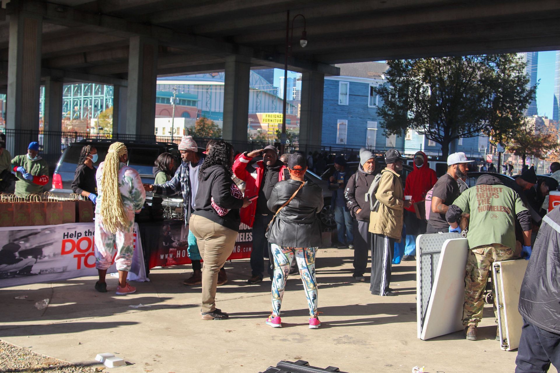 A group of people are standing in front of a sign that says do tc