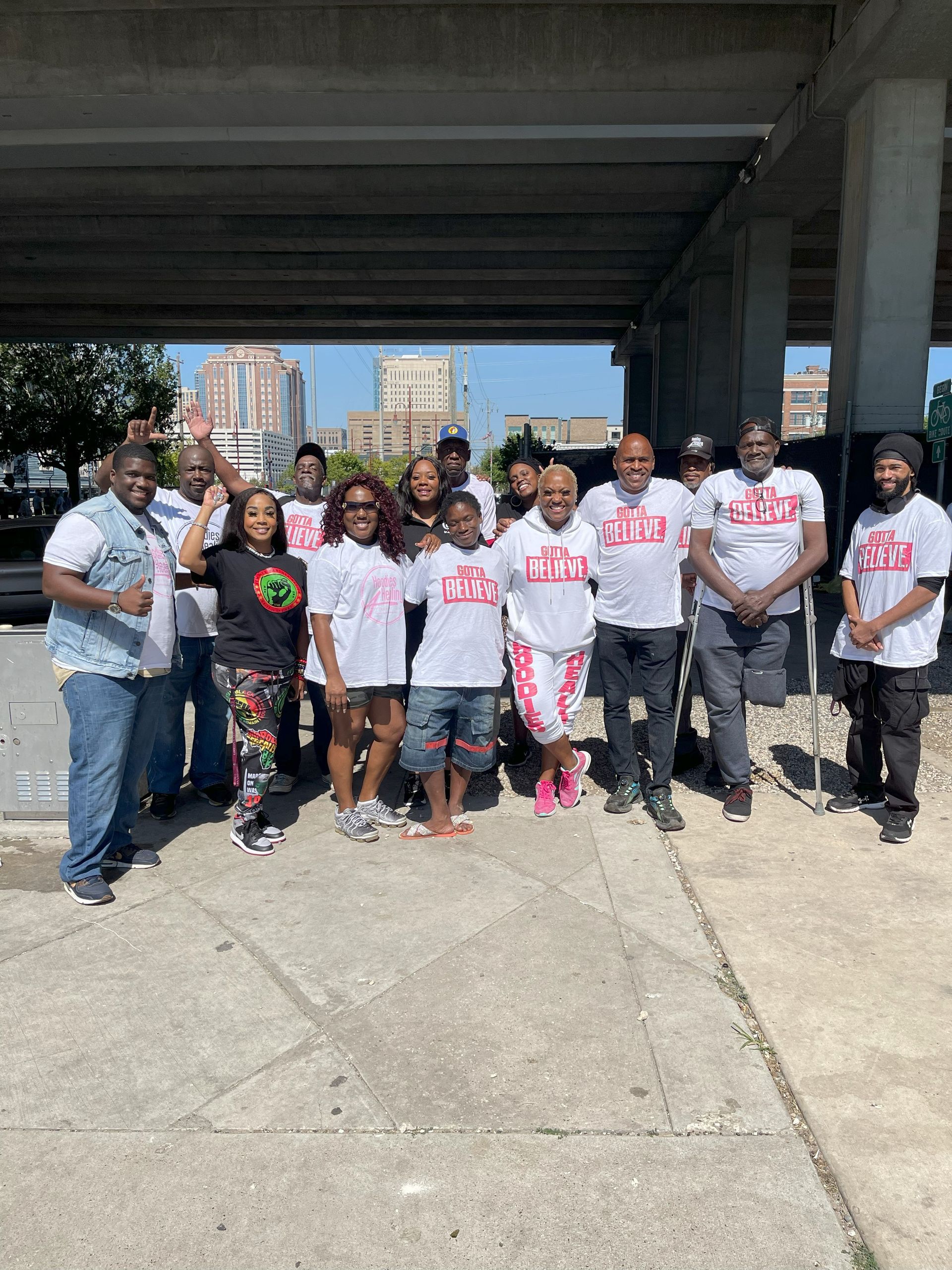 A group of people are posing for a picture under a bridge.