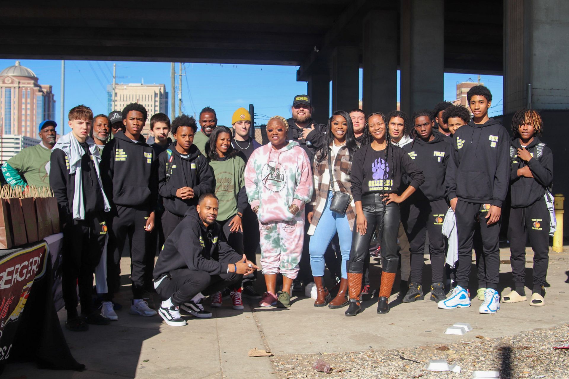 A group of people are posing for a picture under a bridge.