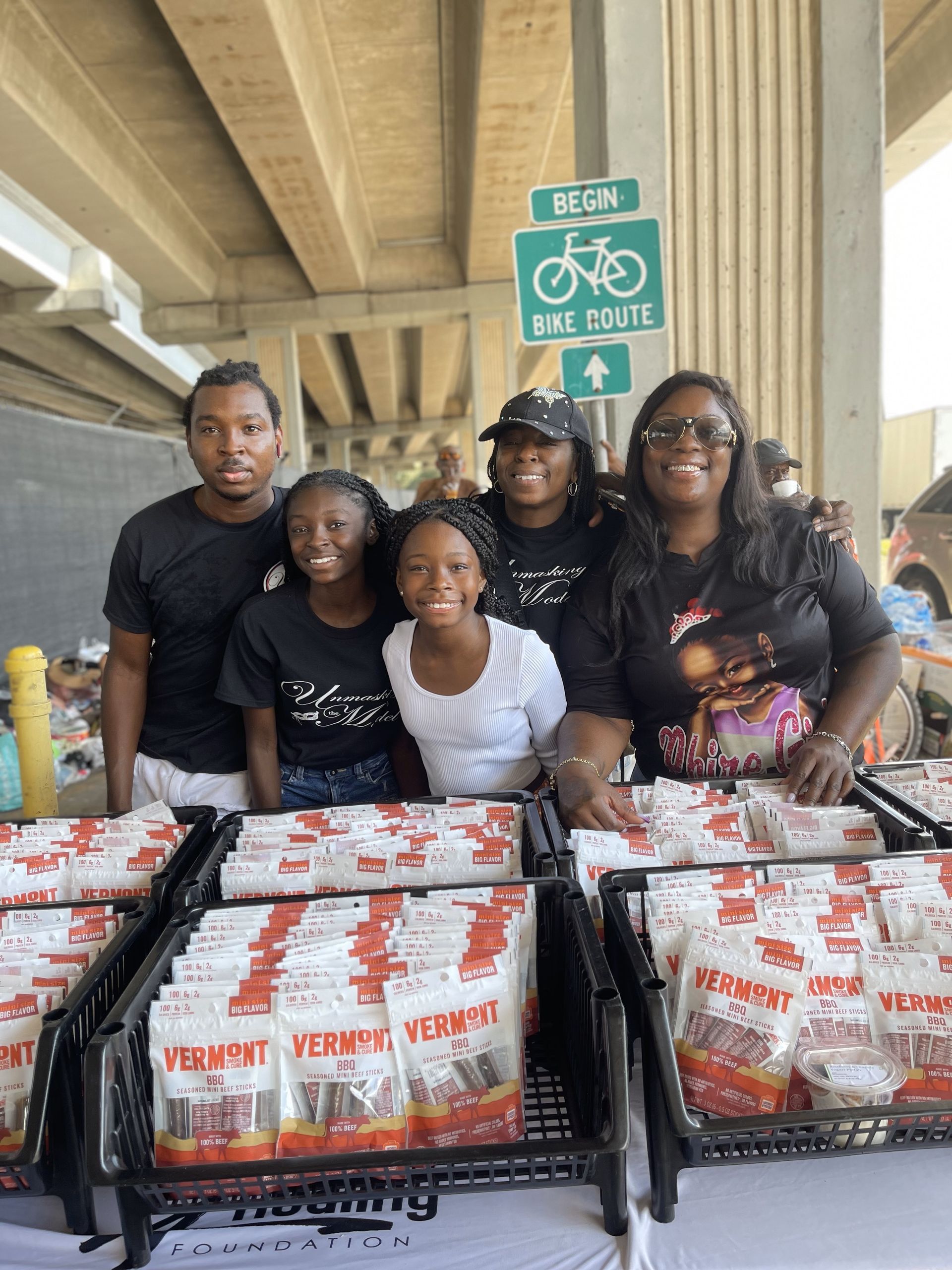 A group of people are posing for a picture in front of a bike path sign.