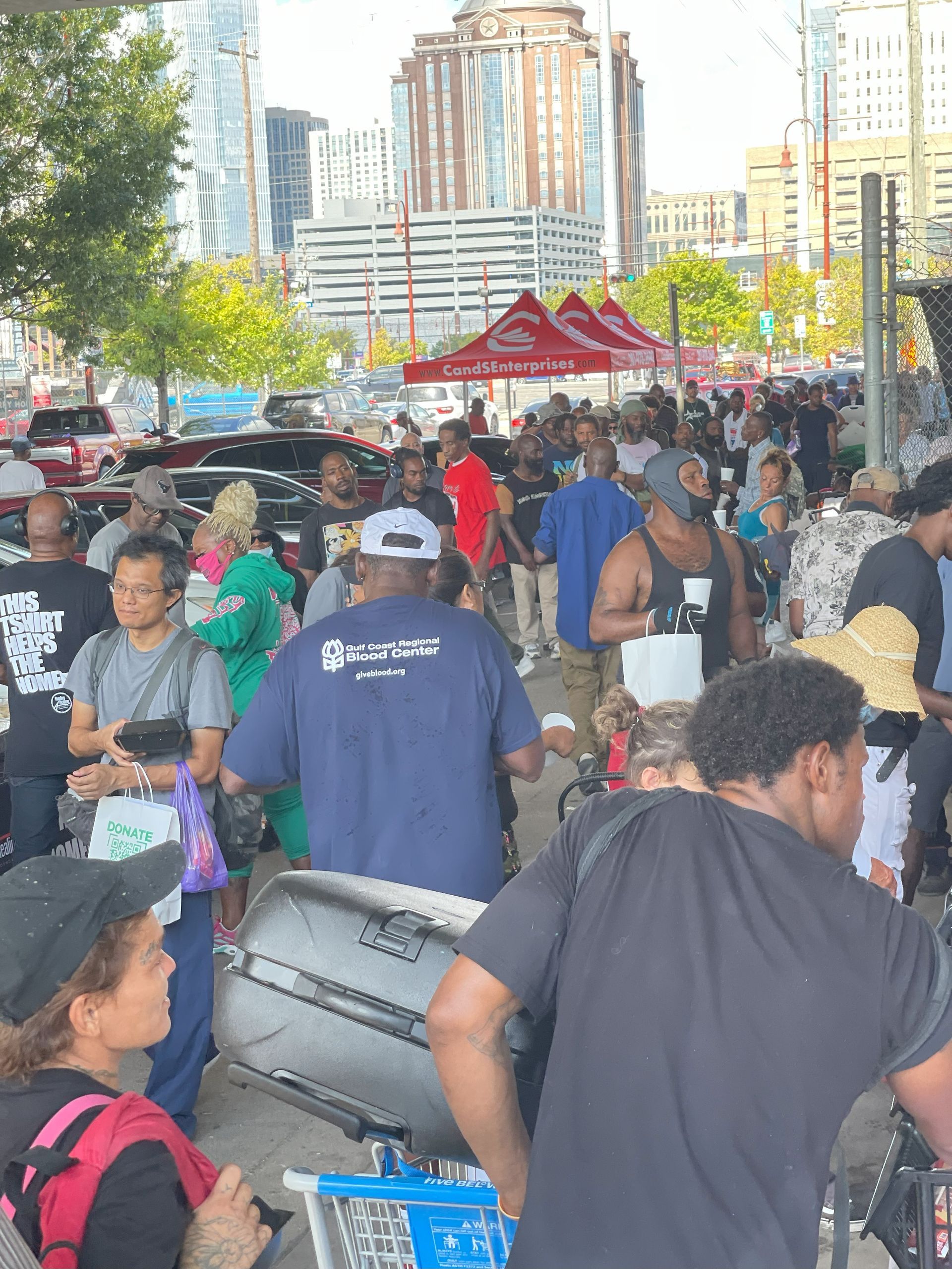 A crowd of people are gathered in a parking lot