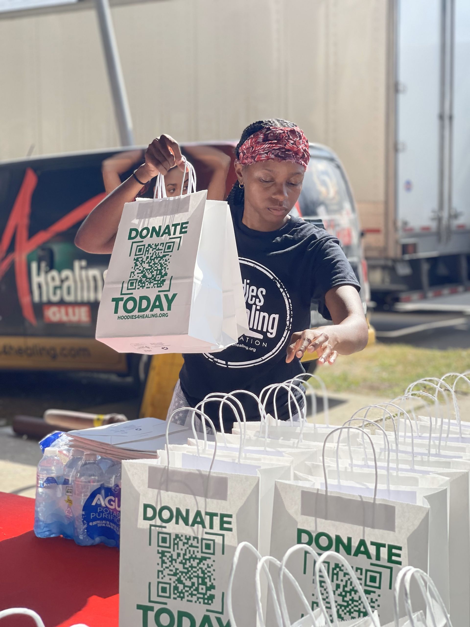A woman is holding a bag that says donate today