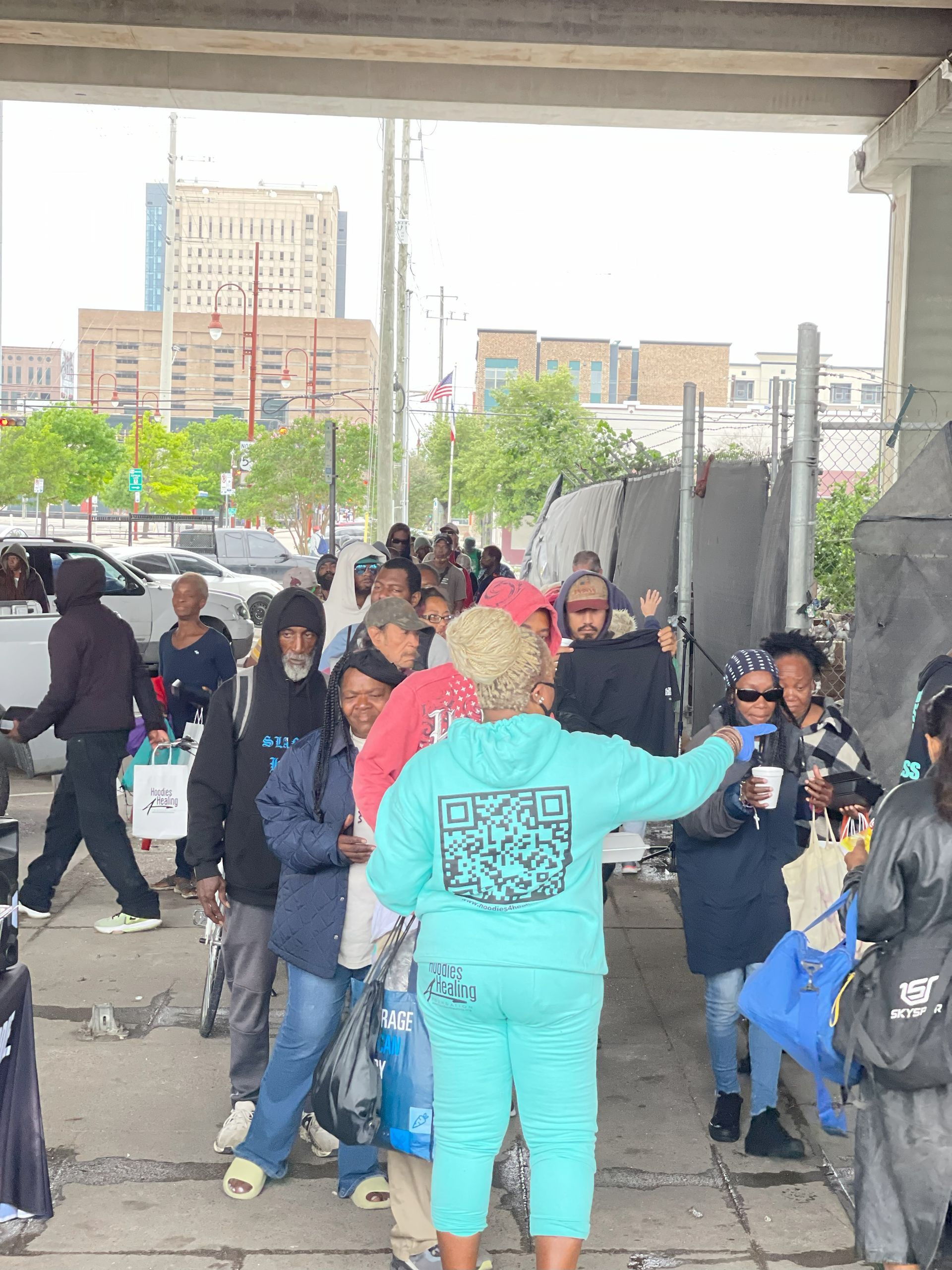 A woman in a blue hoodie stands in a crowd of people