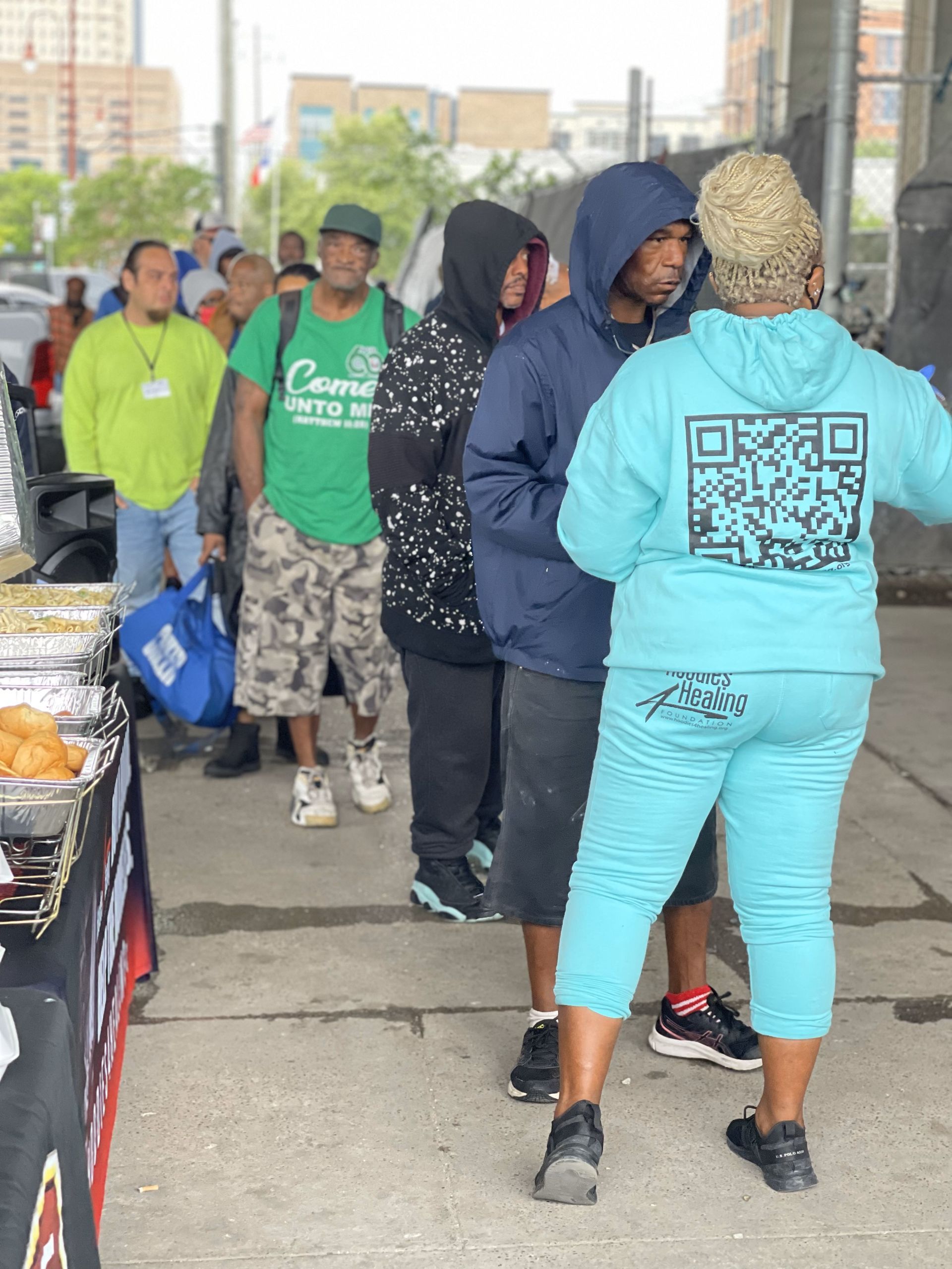 A woman in a blue hoodie with a qr code on the back