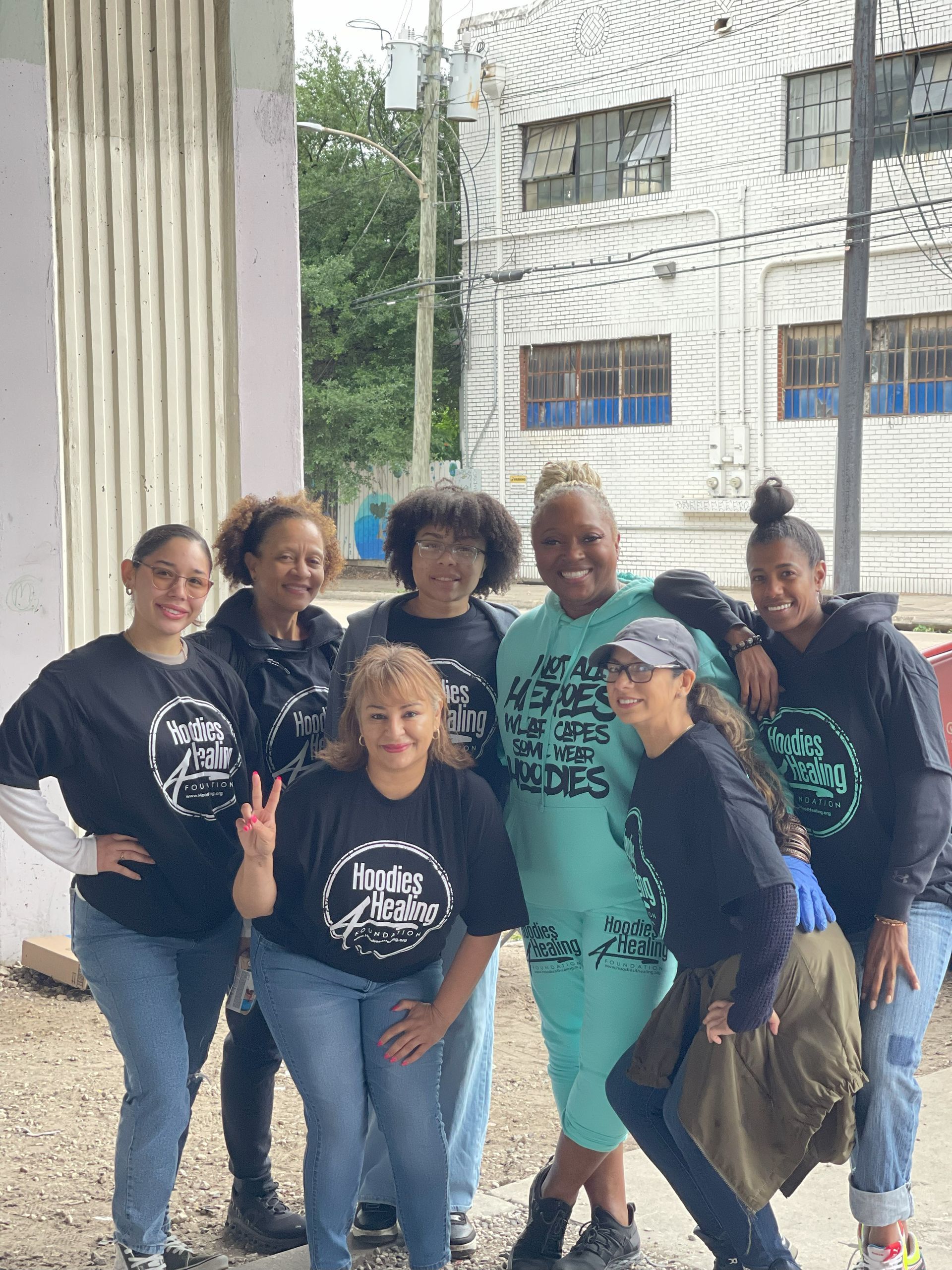 A group of women are posing for a picture in front of a building.