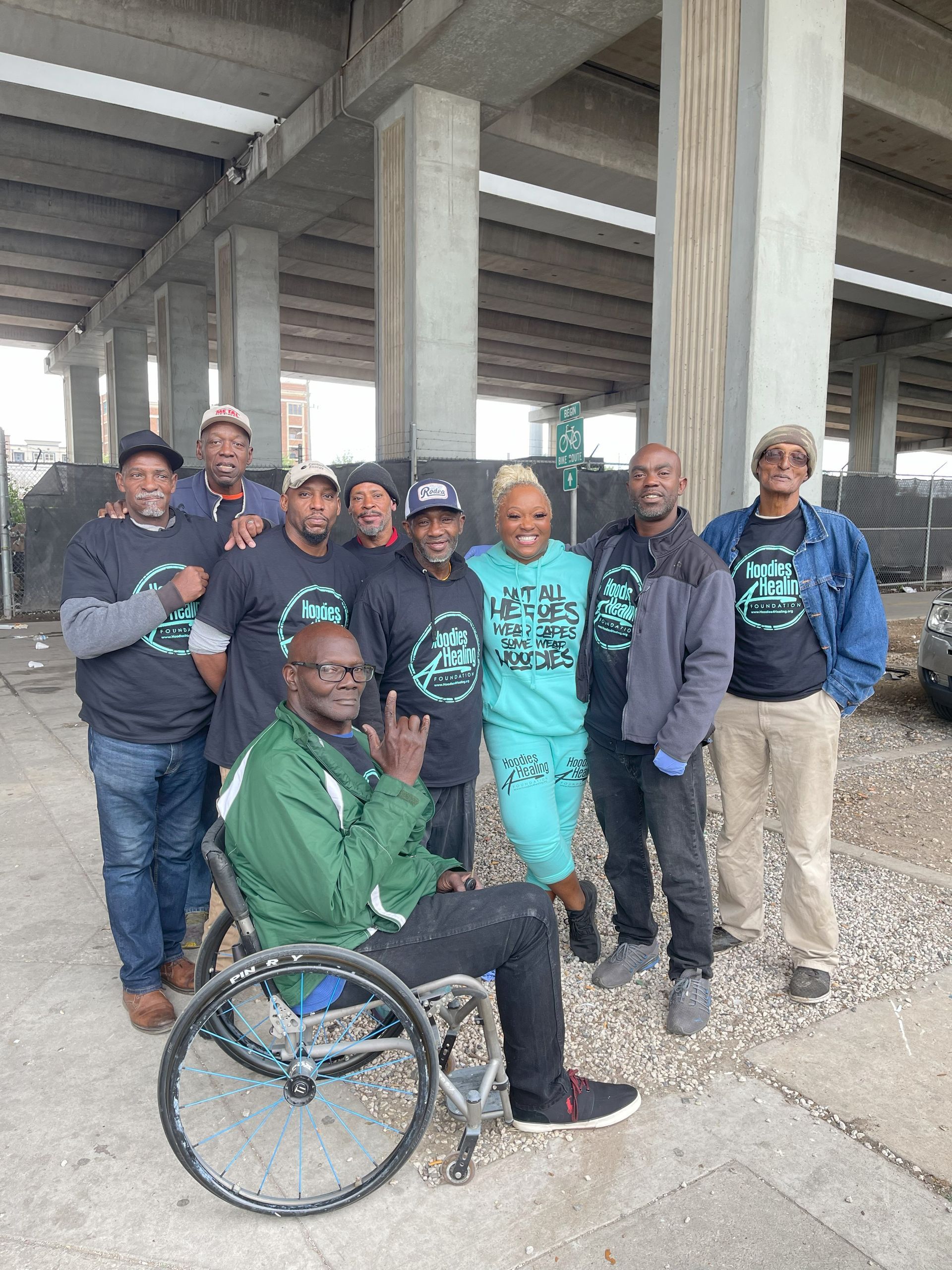 A group of people posing for a picture with one man in a wheelchair