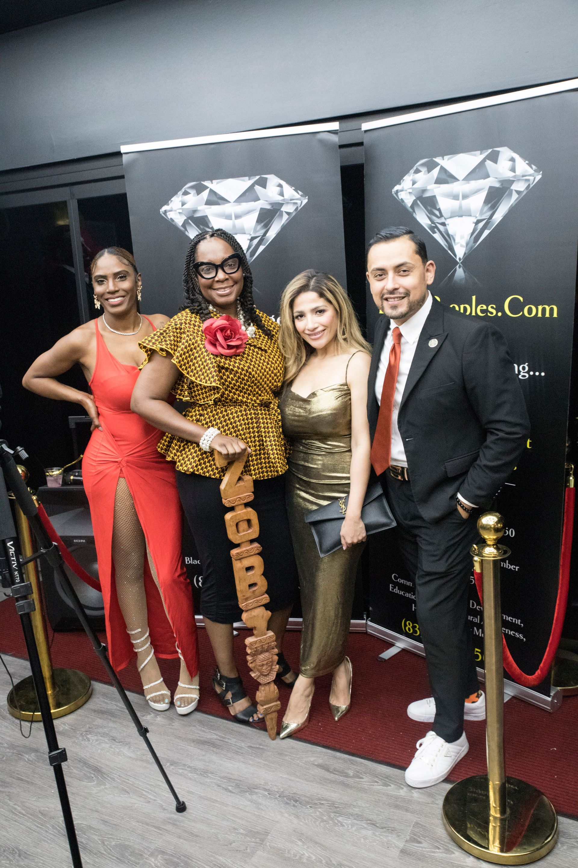 A group of people are posing for a picture on a red carpet.