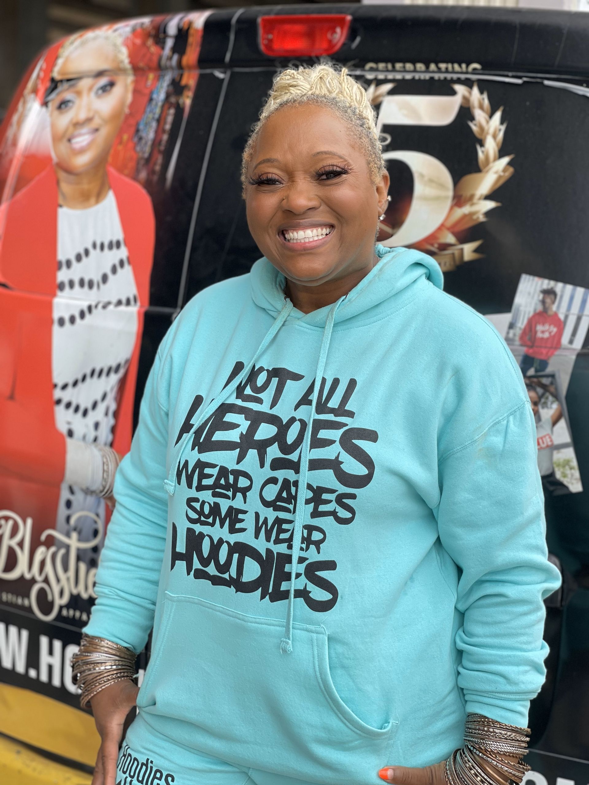 A woman wearing a hoodie that says not all heroes wear capes some wear hoodies