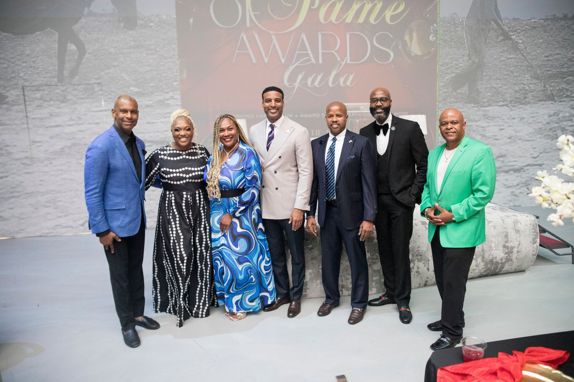 A group of people are posing for a picture in front of a wall.