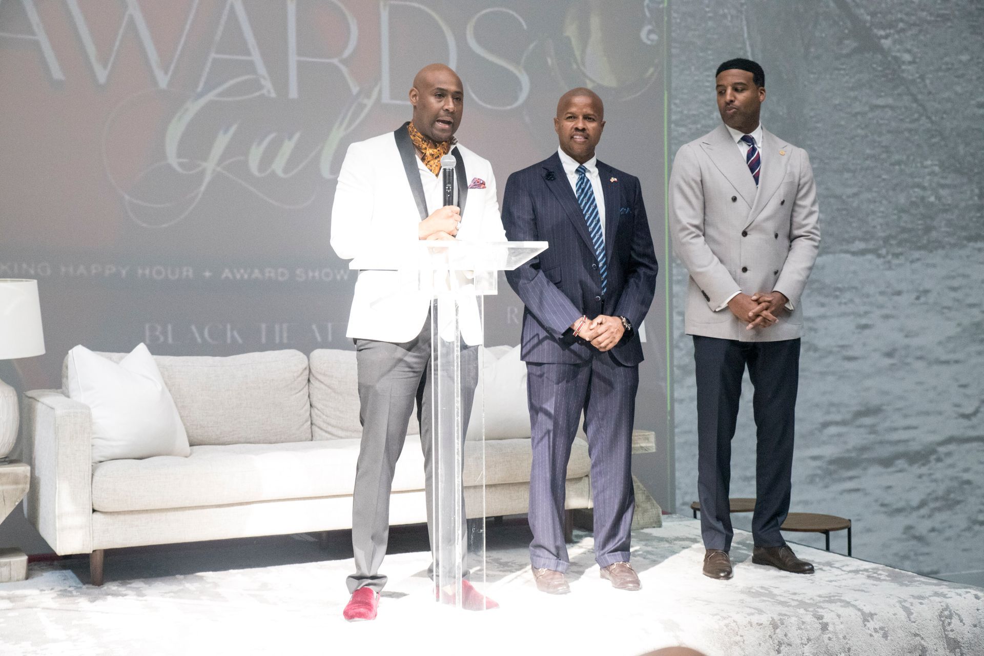 Three men are standing next to each other in front of a podium.