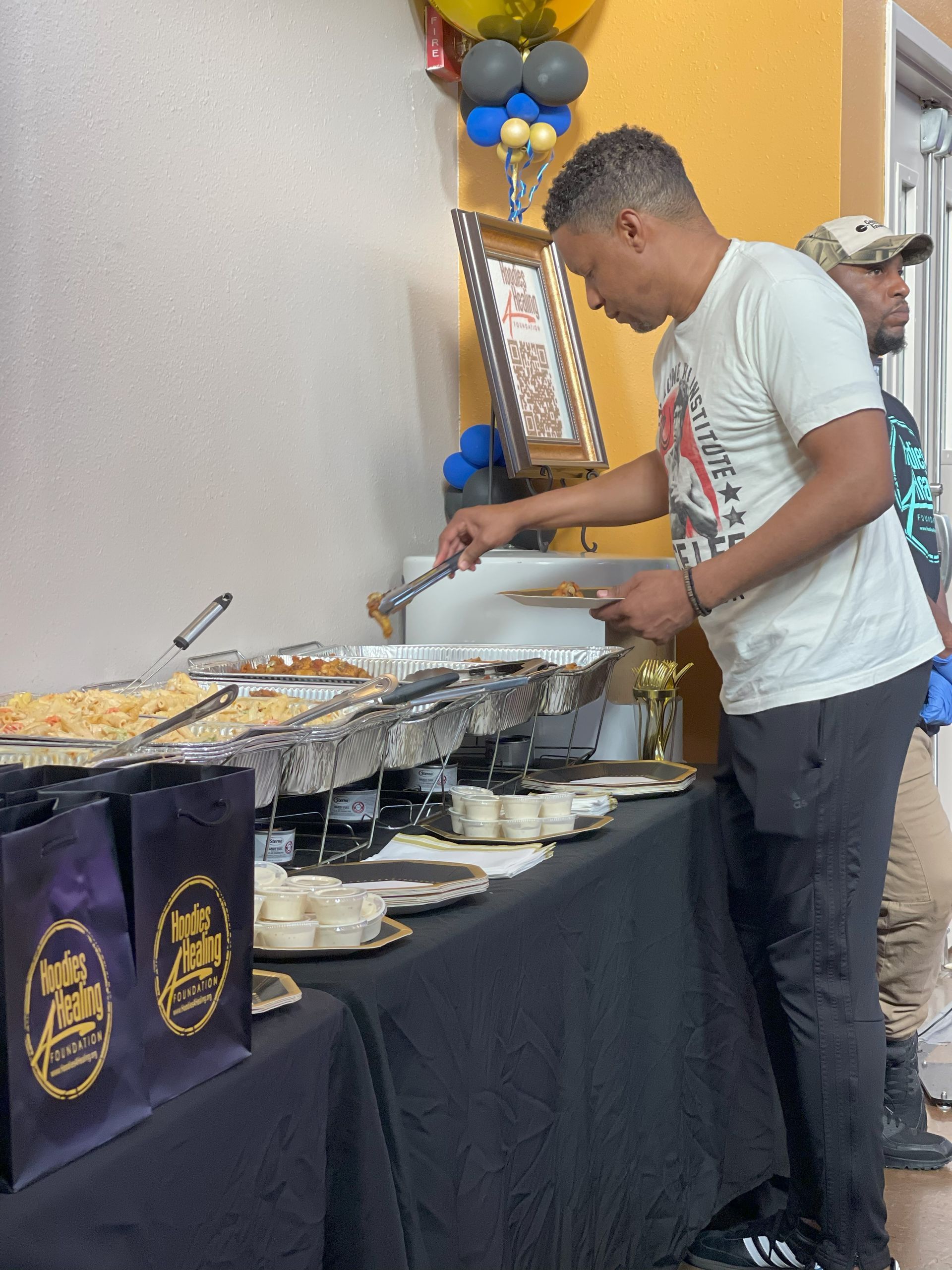 A man in a white shirt is standing at a buffet table
