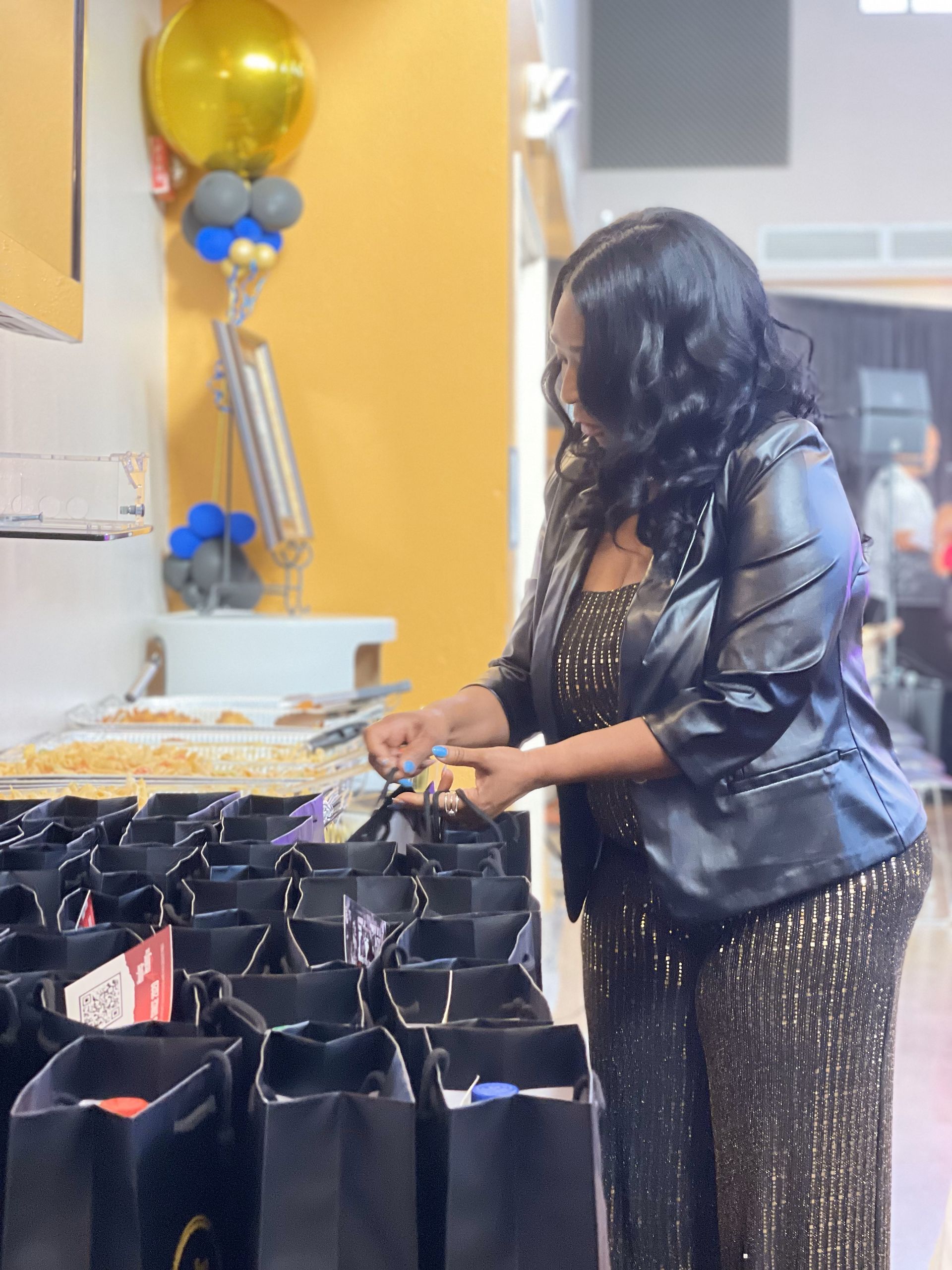 A woman is standing in front of a row of bags.