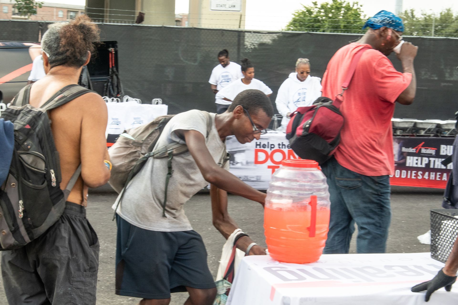 A man is pouring a drink from a pitcher at a table.