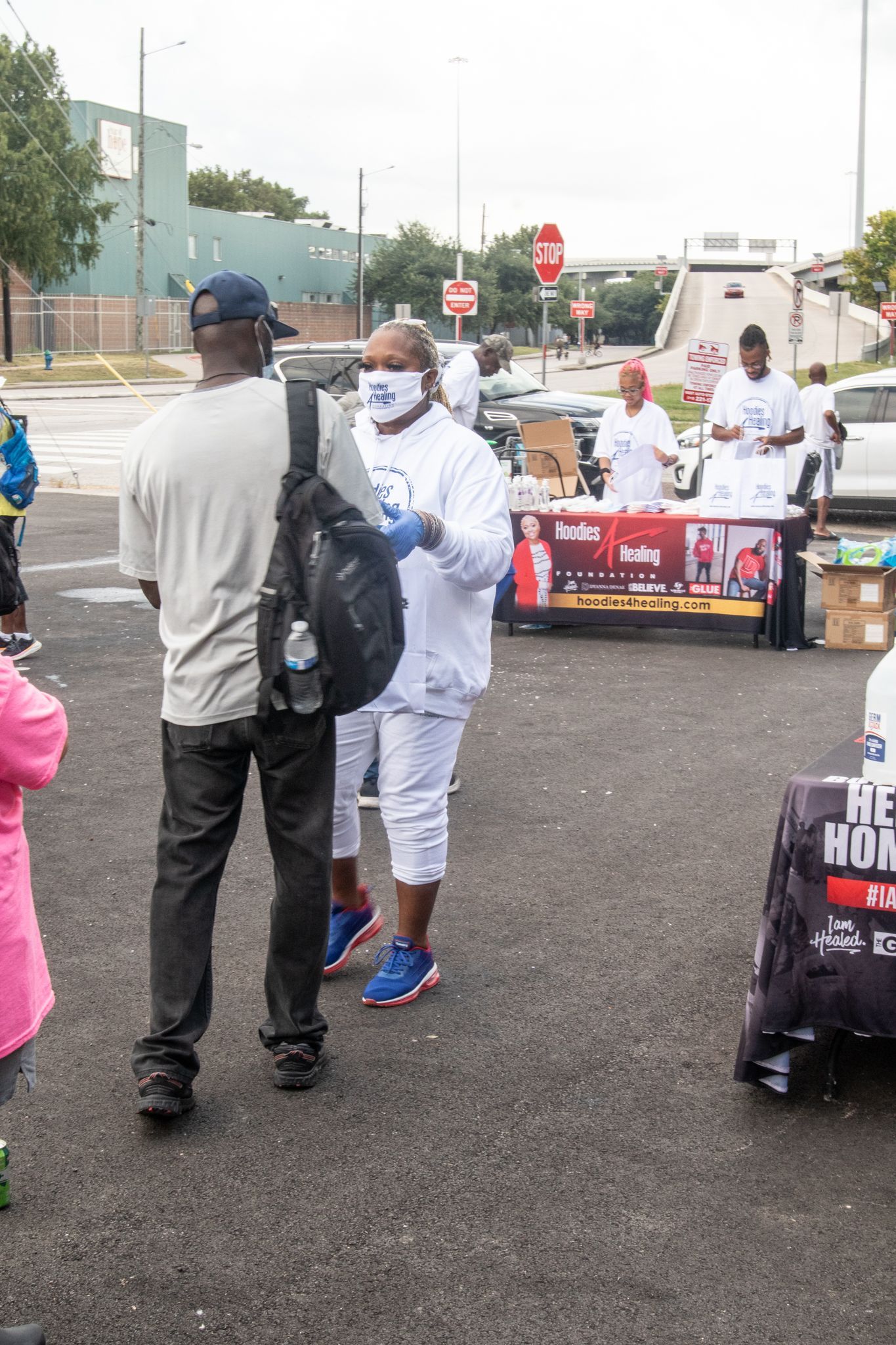 A group of people are standing in a parking lot talking to each other.