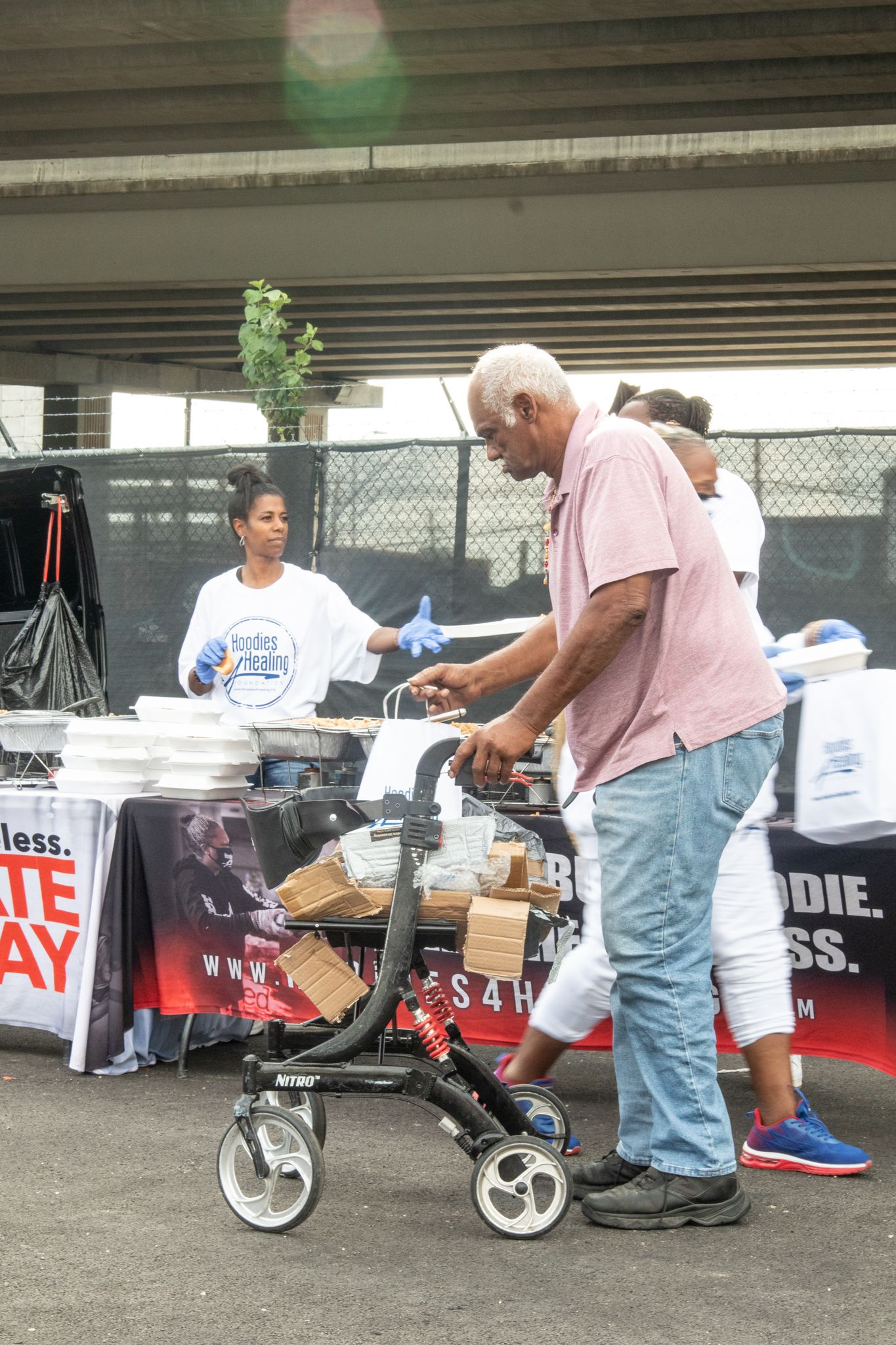A man with a walker is standing in front of a table.