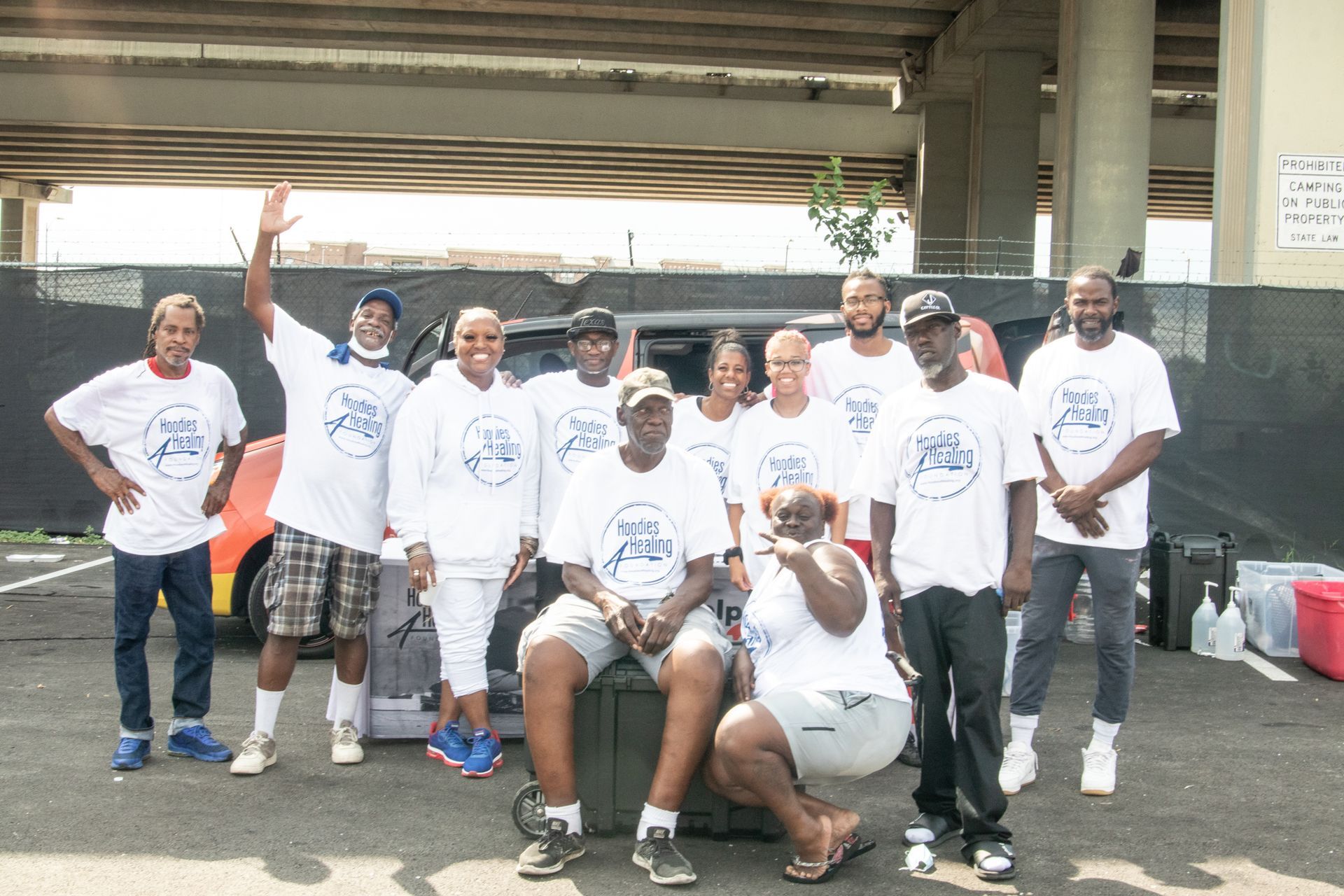 A group of people are posing for a picture in a parking lot.