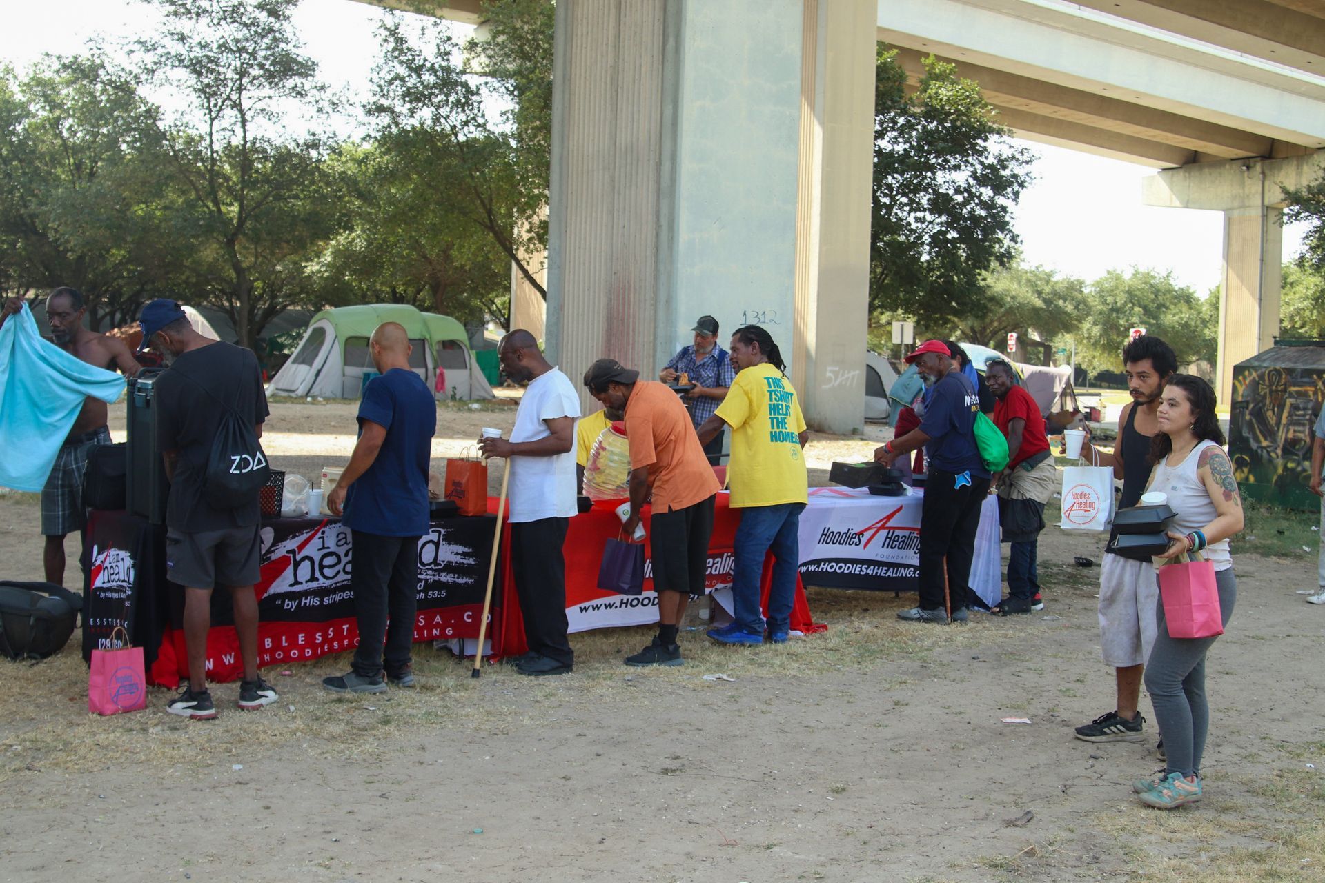 A group of people are standing around a table with a sign that says ' do n't ' on it