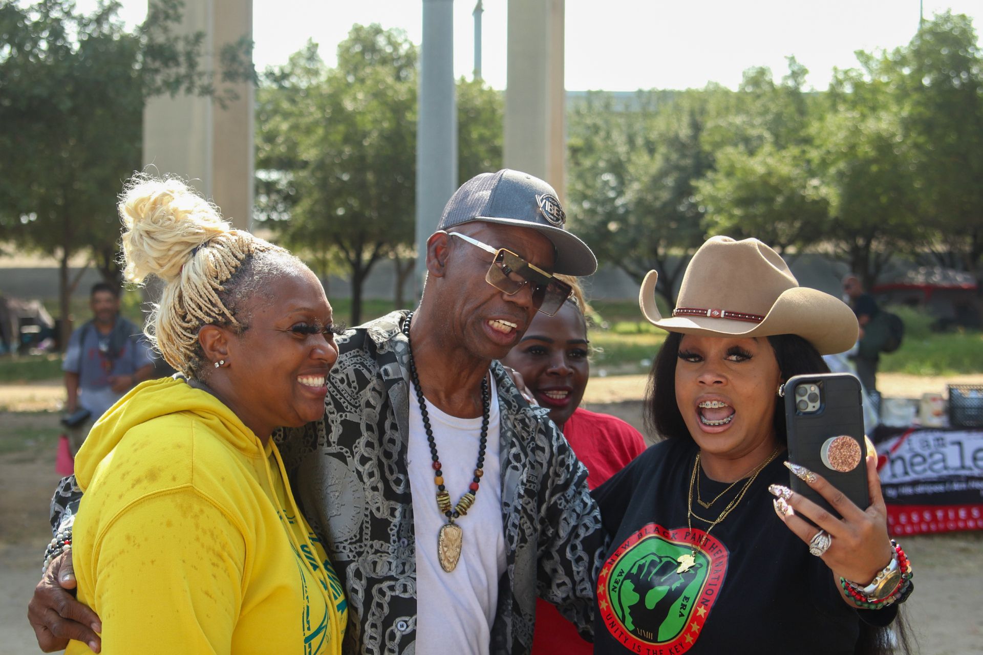 A group of people are posing for a picture in a park.