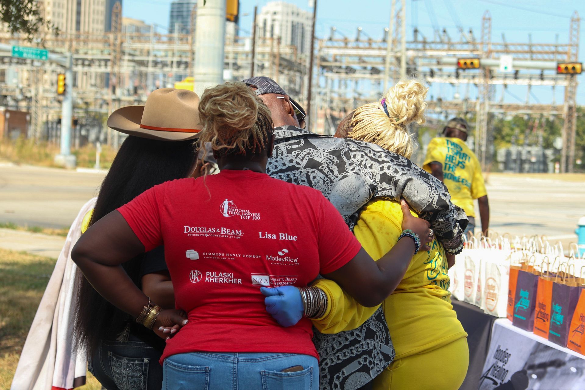 A group of people are hugging each other in a park.