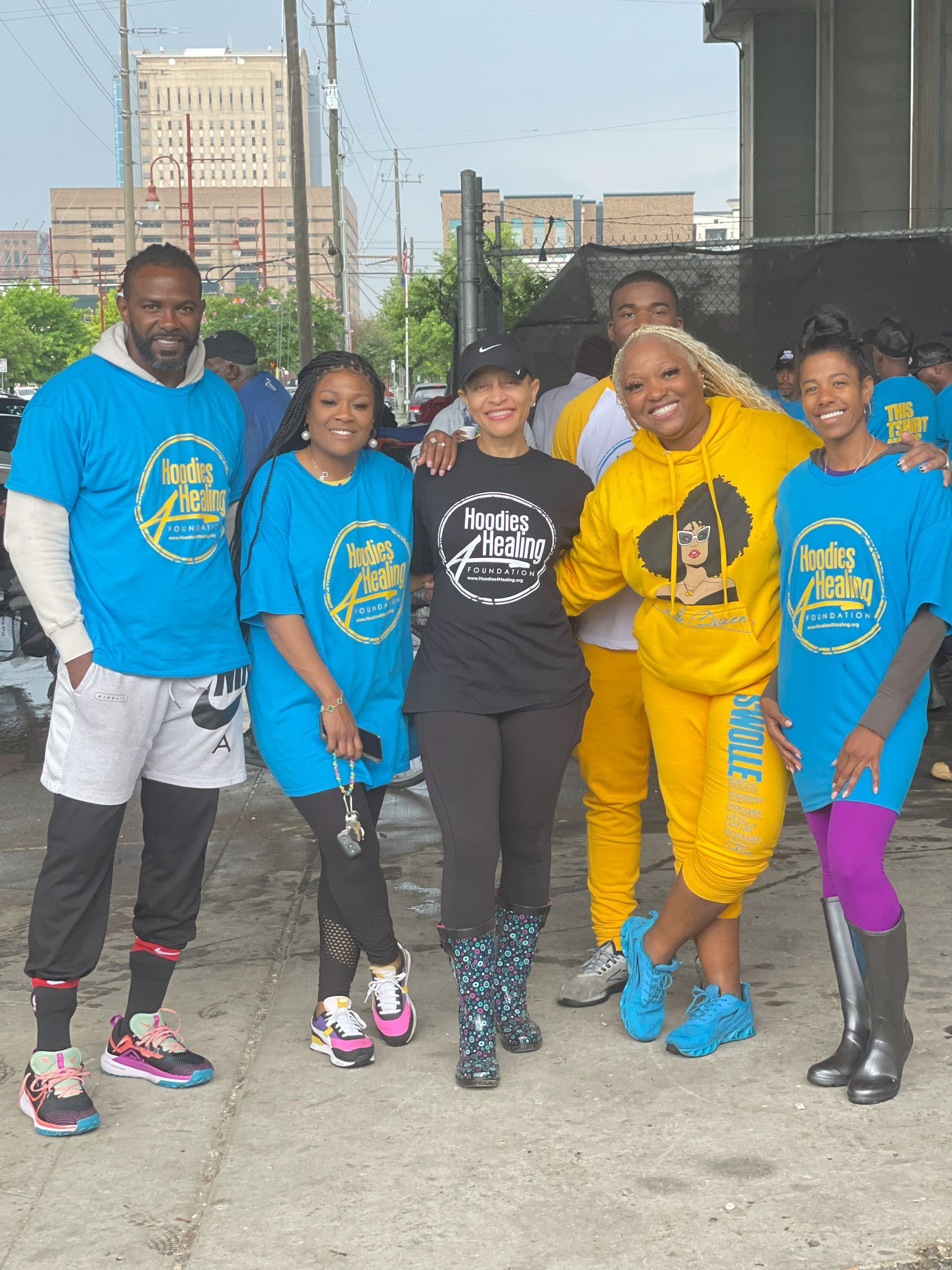 A group of people wearing blue and yellow shirts are posing for a picture