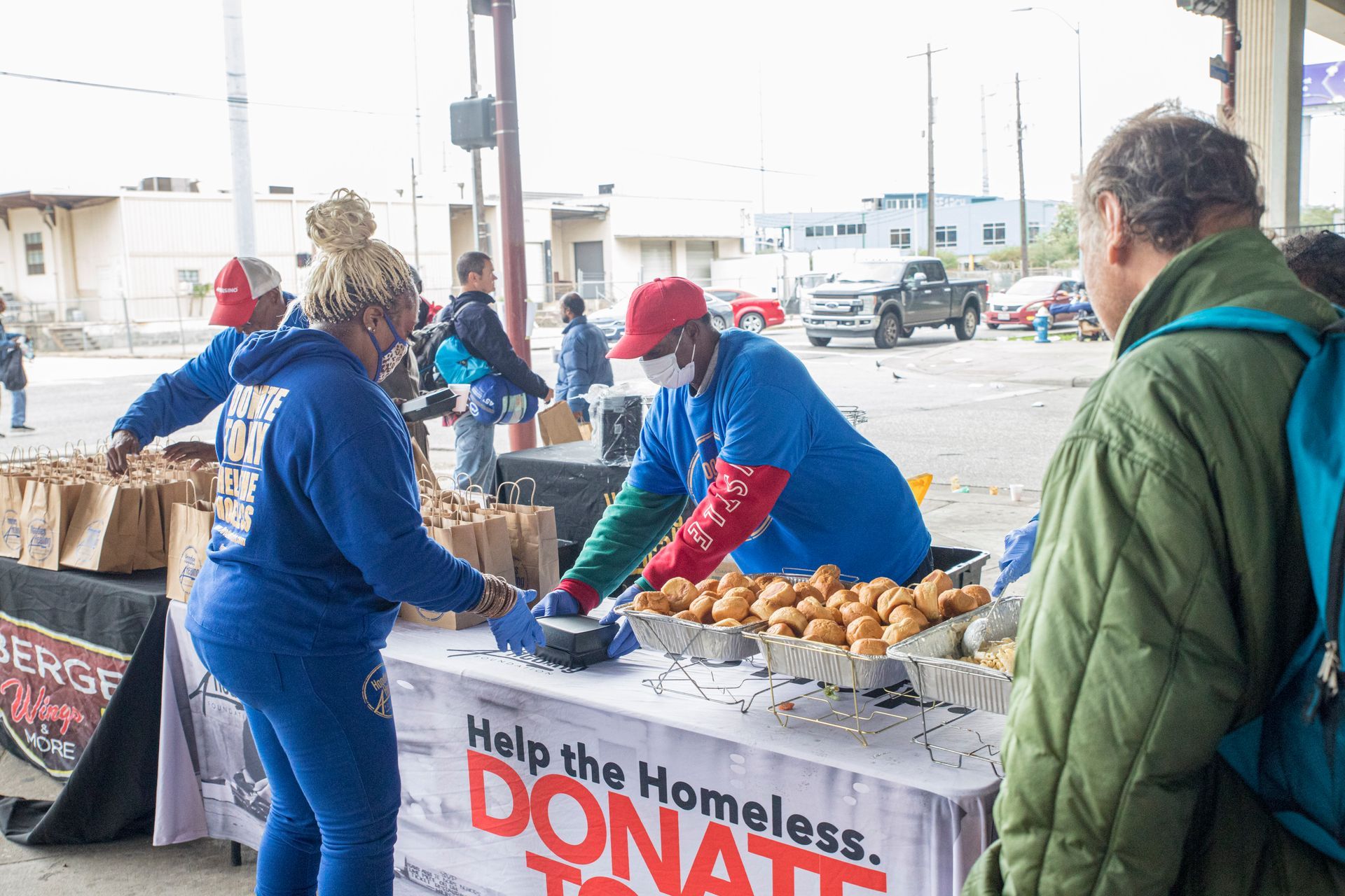 A group of people are standing around a table selling food.