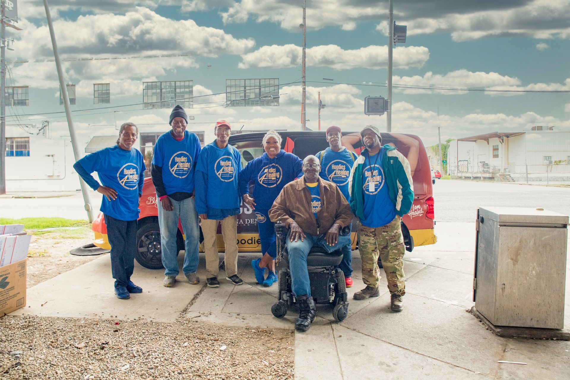 A group of men are posing for a picture in front of a truck.