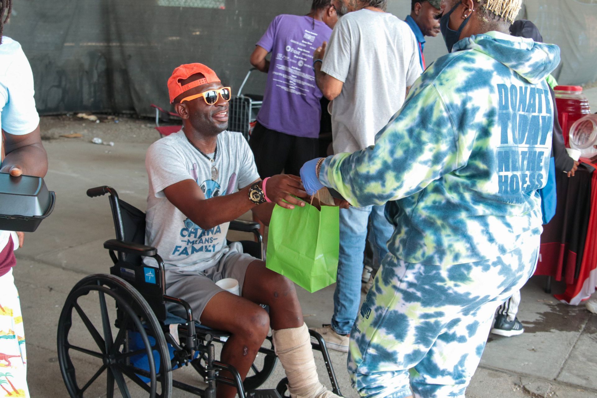 A man in a wheelchair is shaking hands with another man