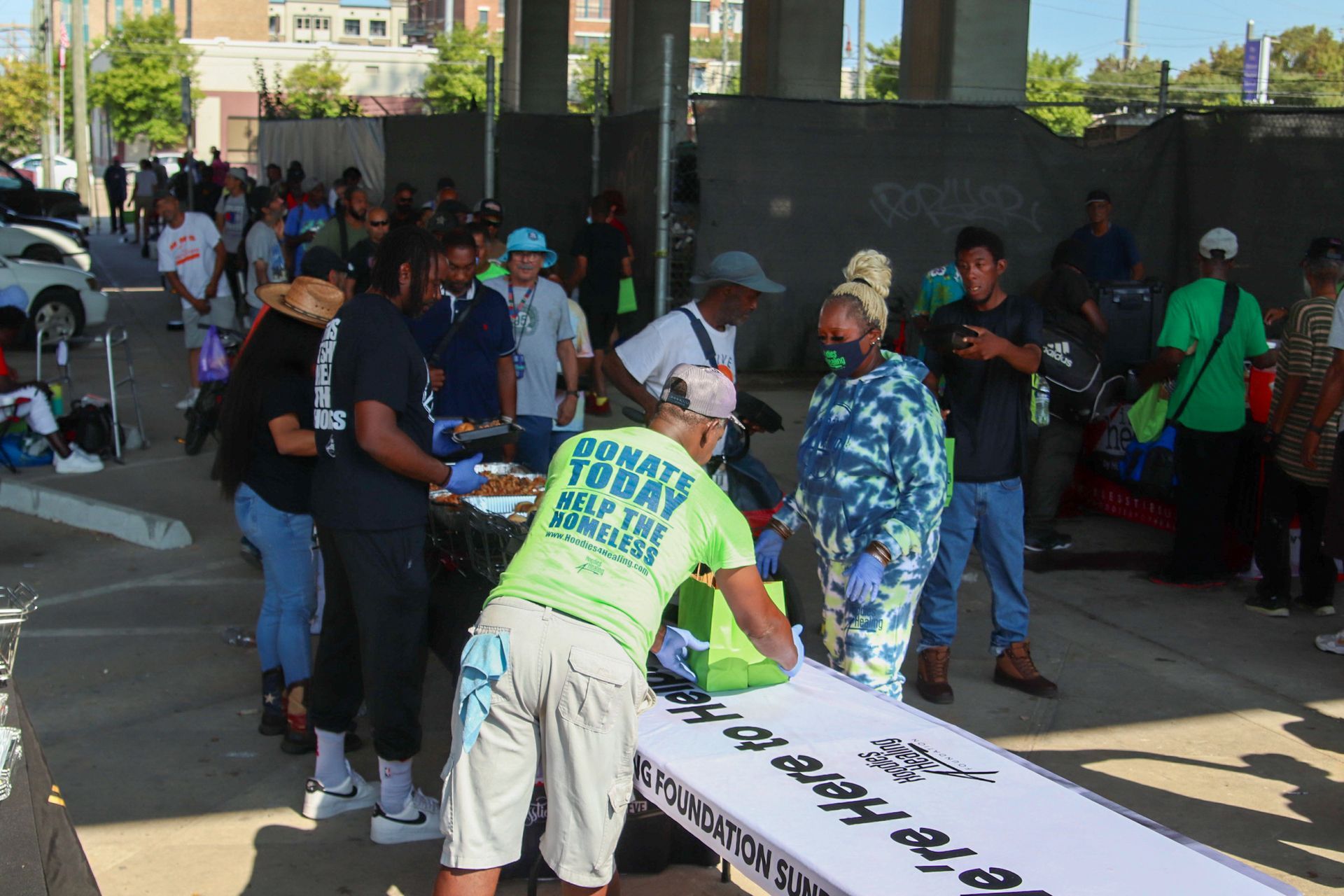 A group of people are standing around a table with a sign that says donate today
