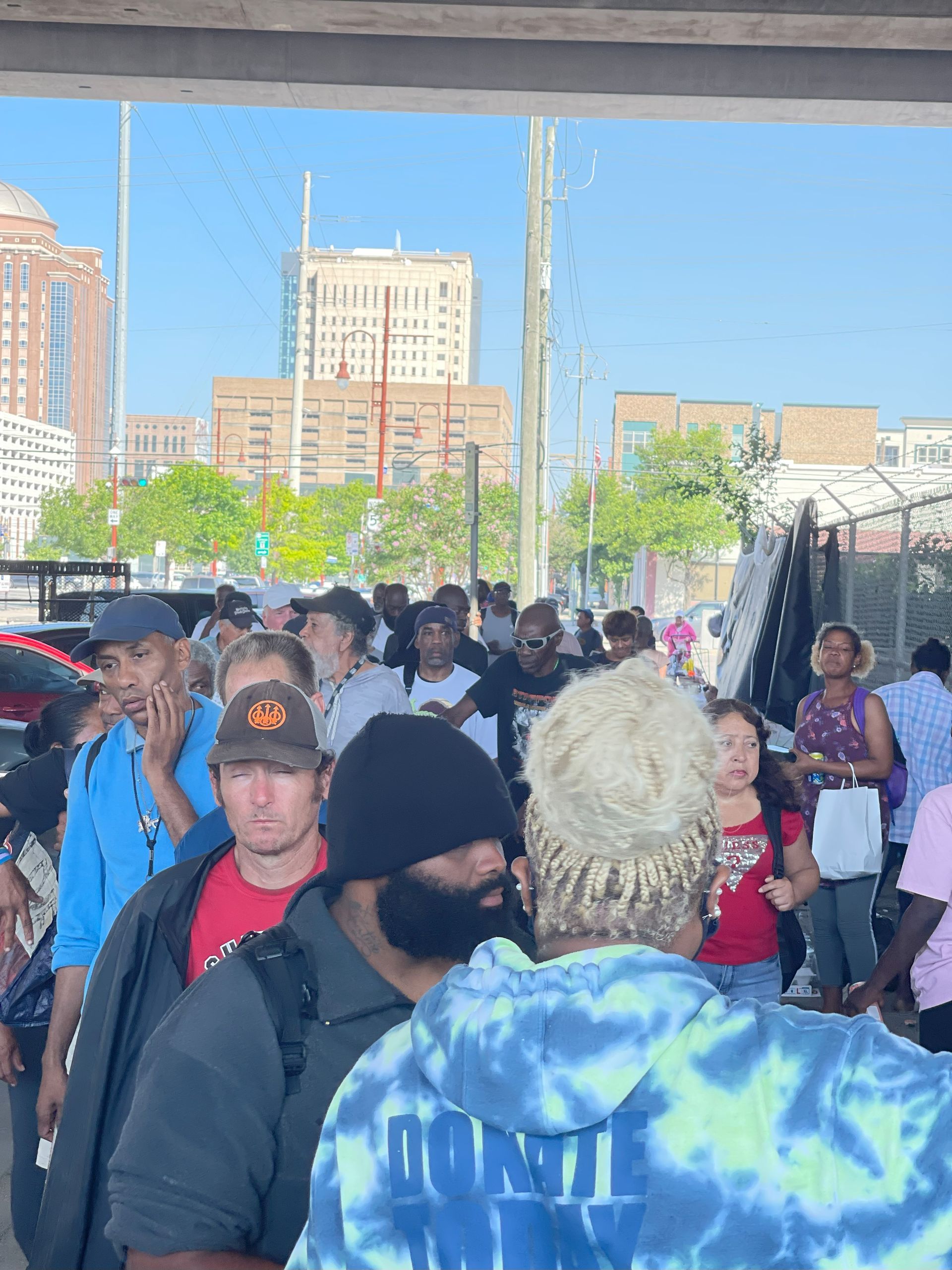 A crowd of people are standing in a line in front of a building.