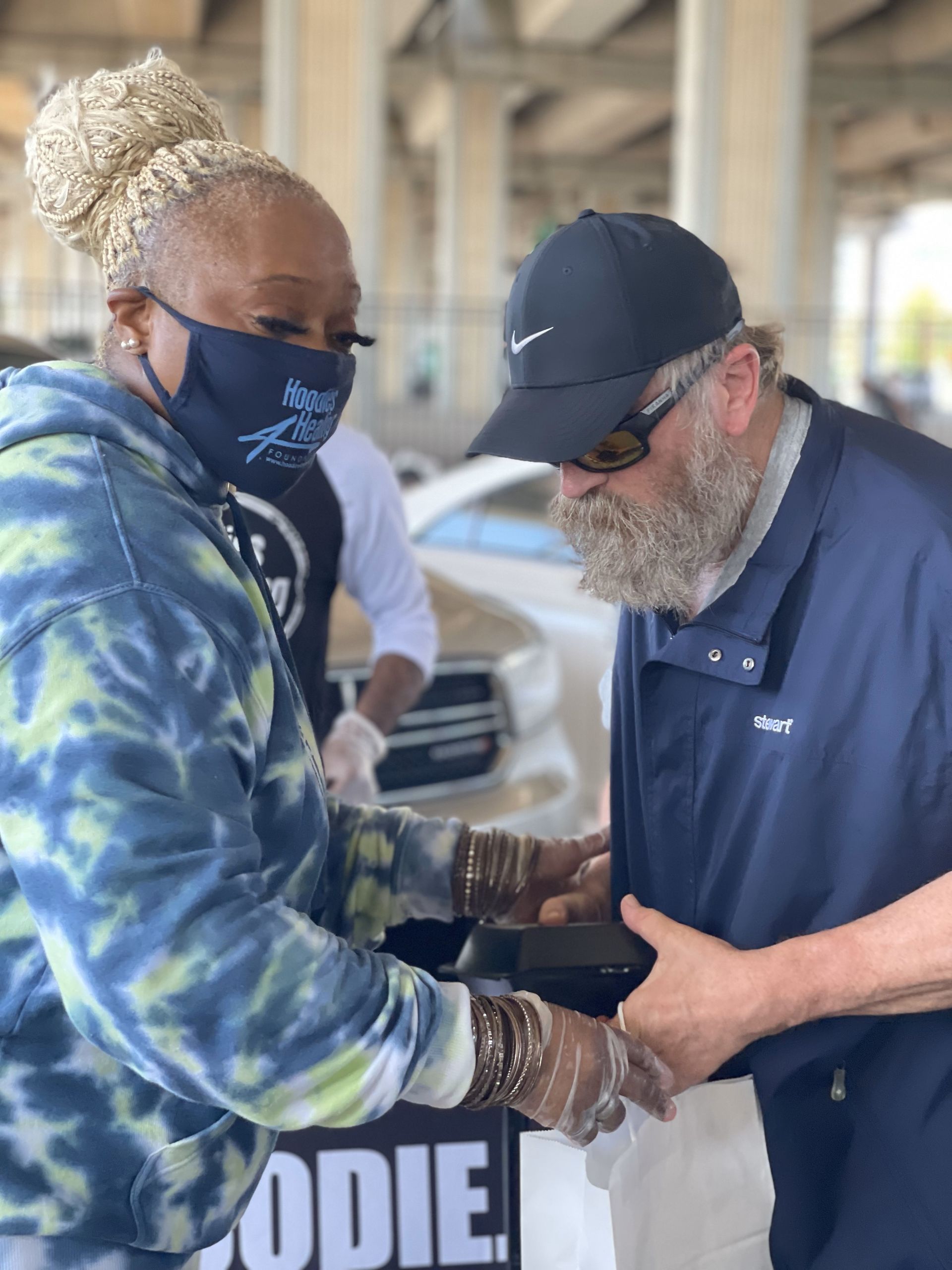 A man and a woman are shaking hands in a parking garage.