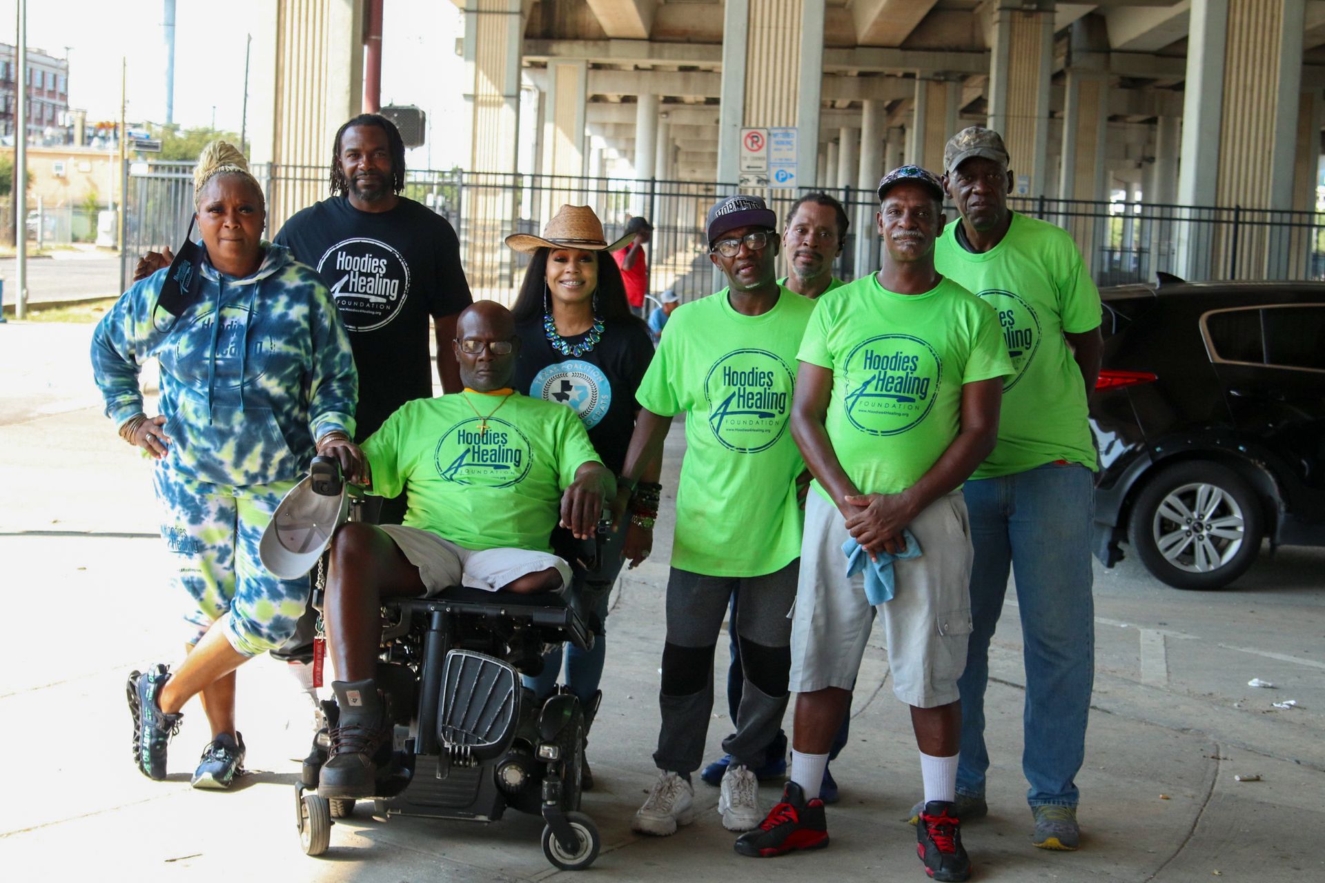 A group of people posing for a picture with one man in a wheelchair