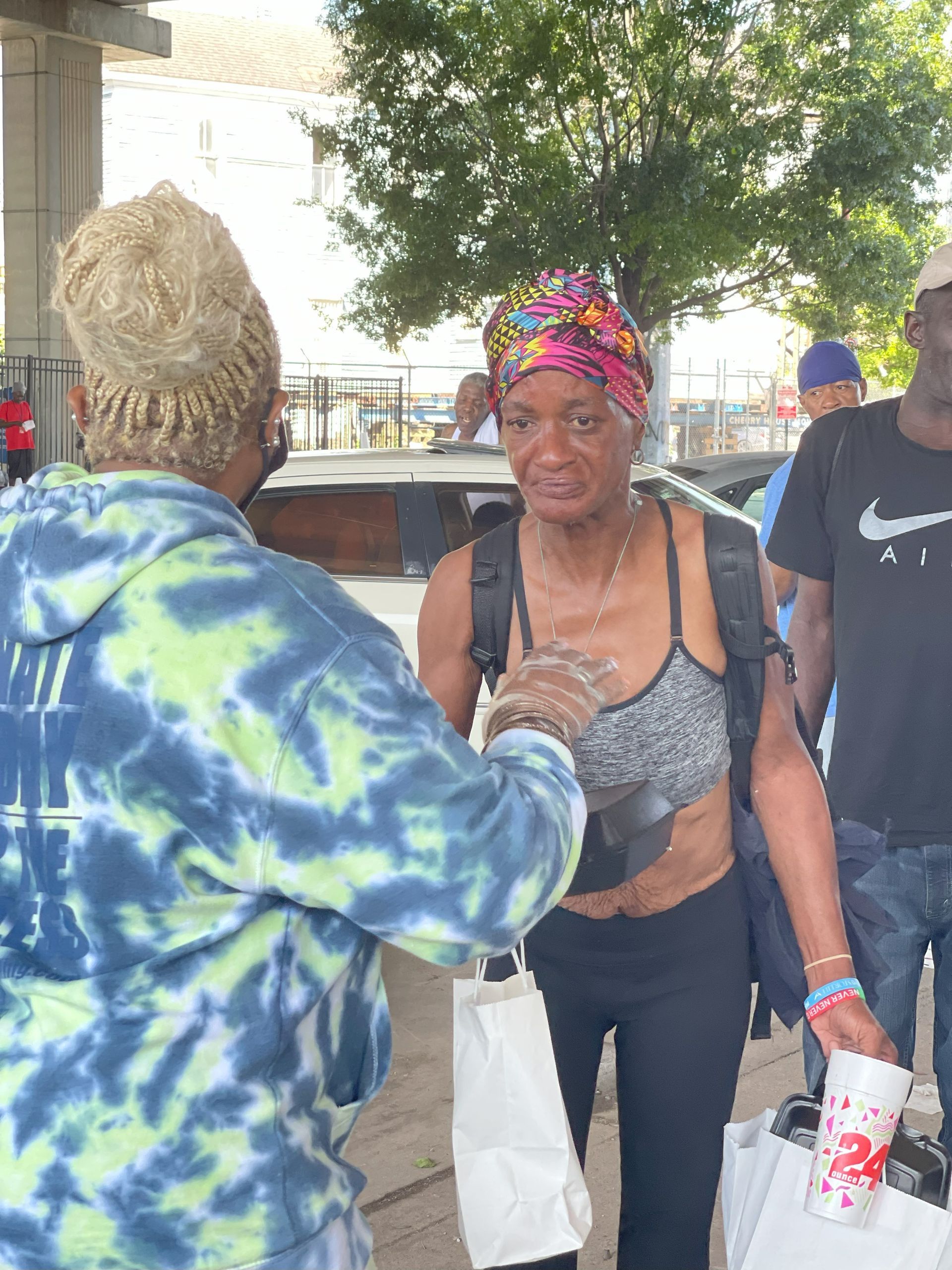 A man in a nike shirt is giving a woman a cup of coffee