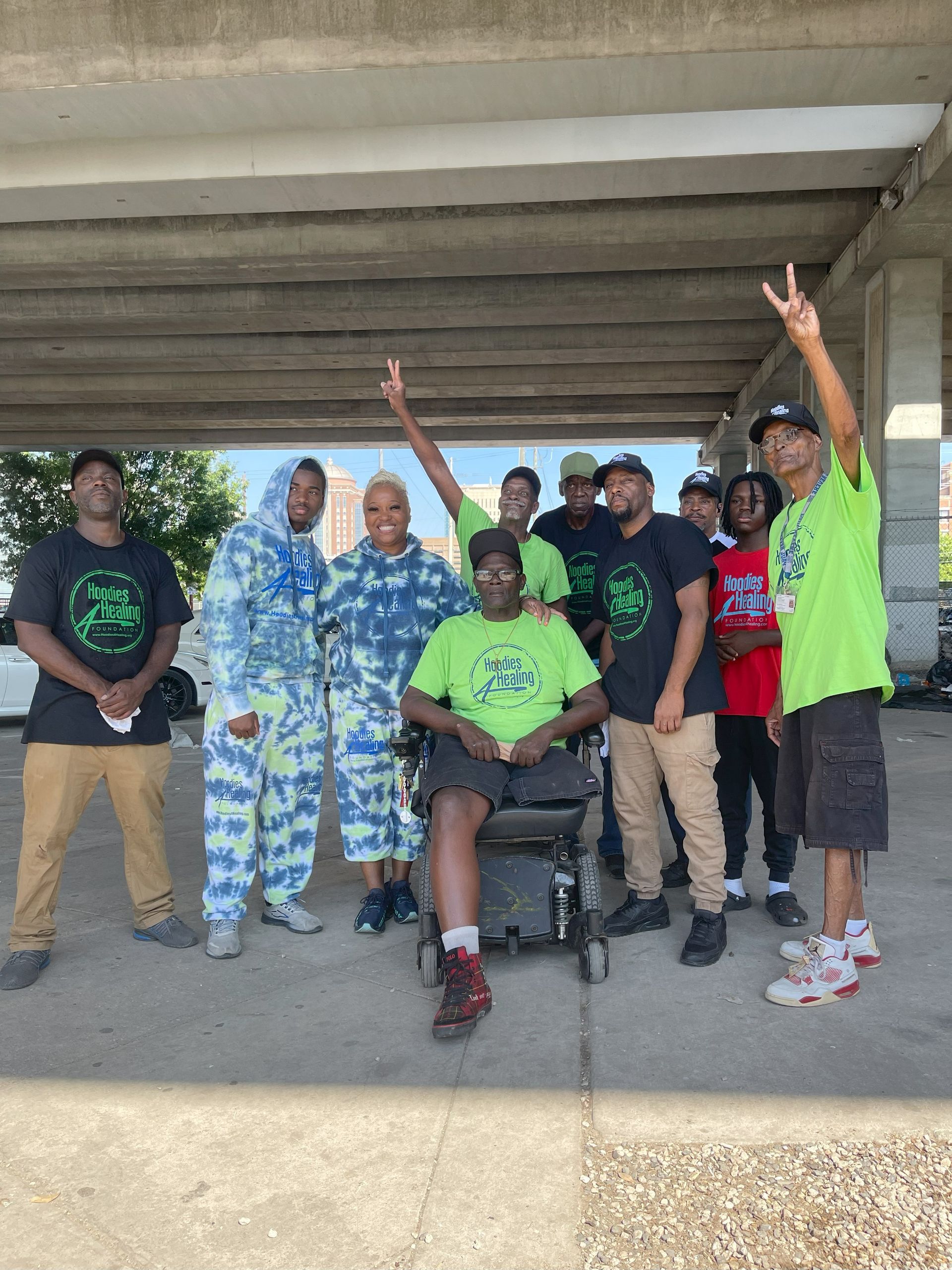 A group of people standing around a man in a wheelchair.