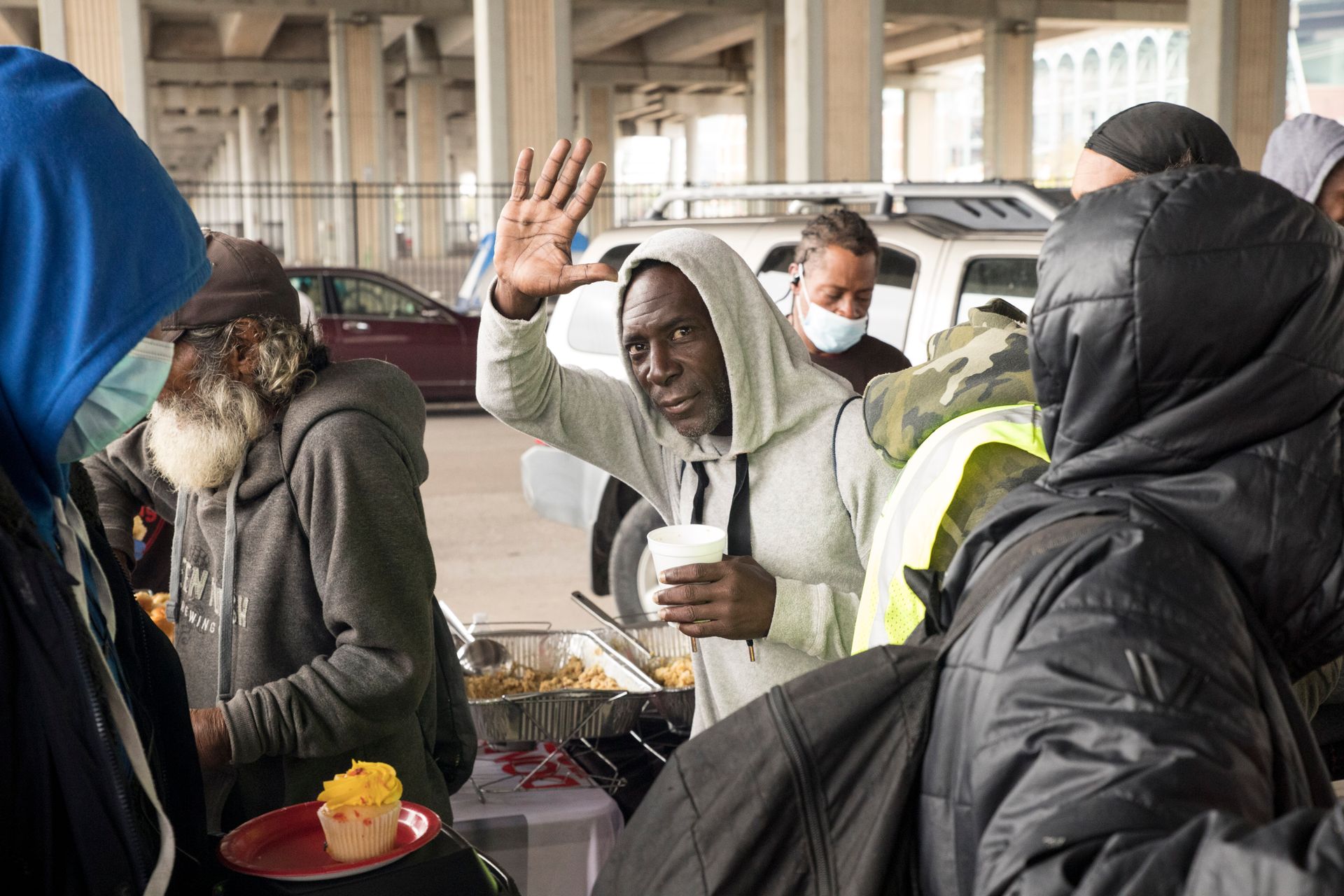 A group of people are standing around a table eating food.