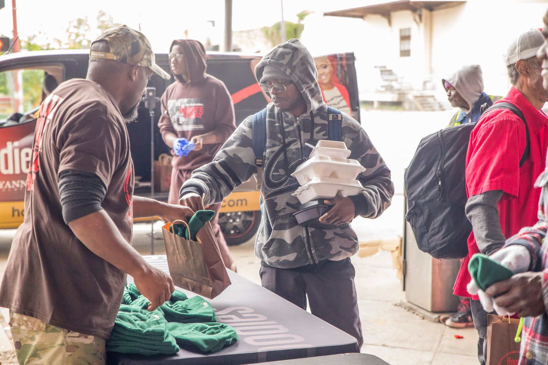 A group of people are standing around a table.
