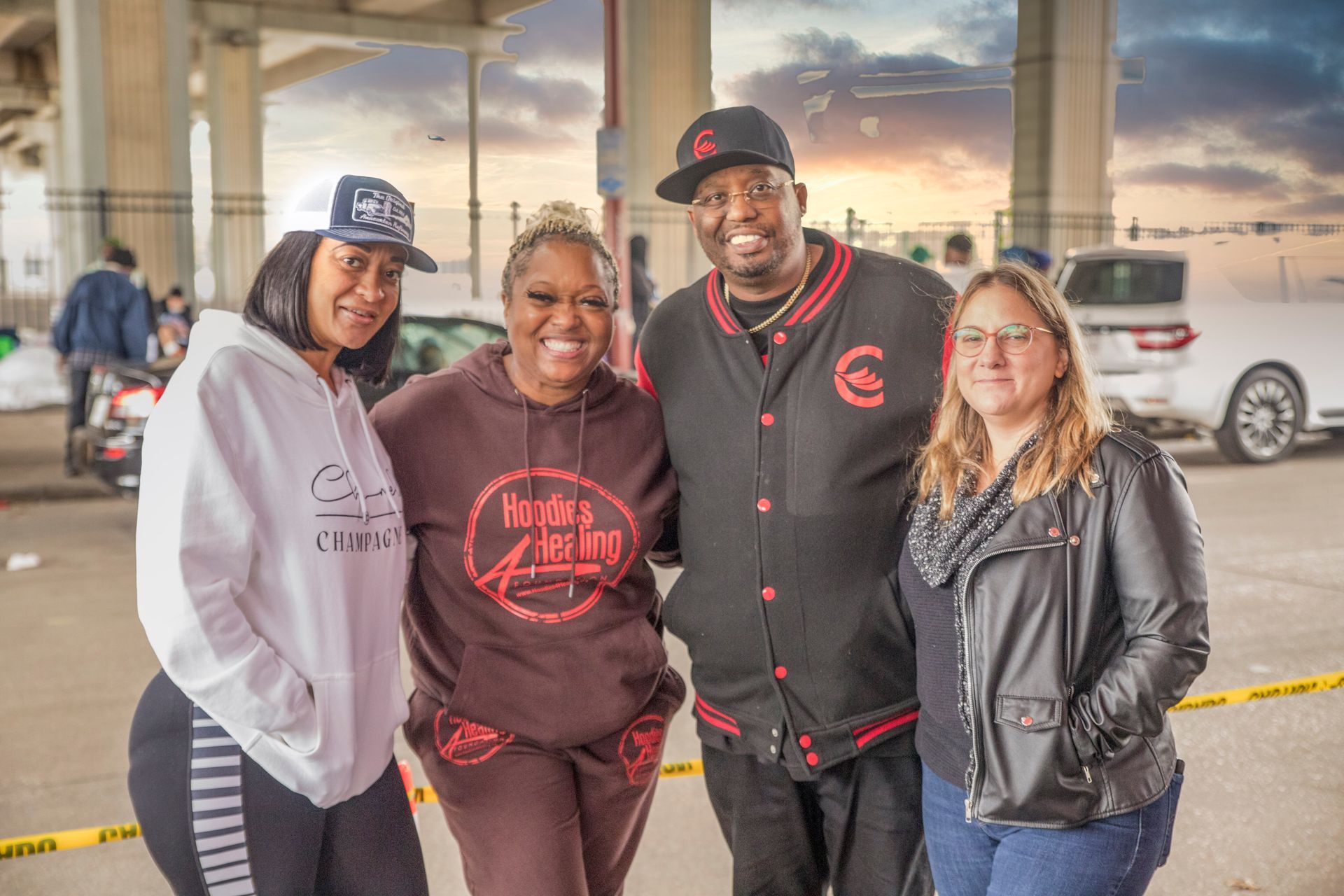 A group of people are posing for a picture in a parking lot.