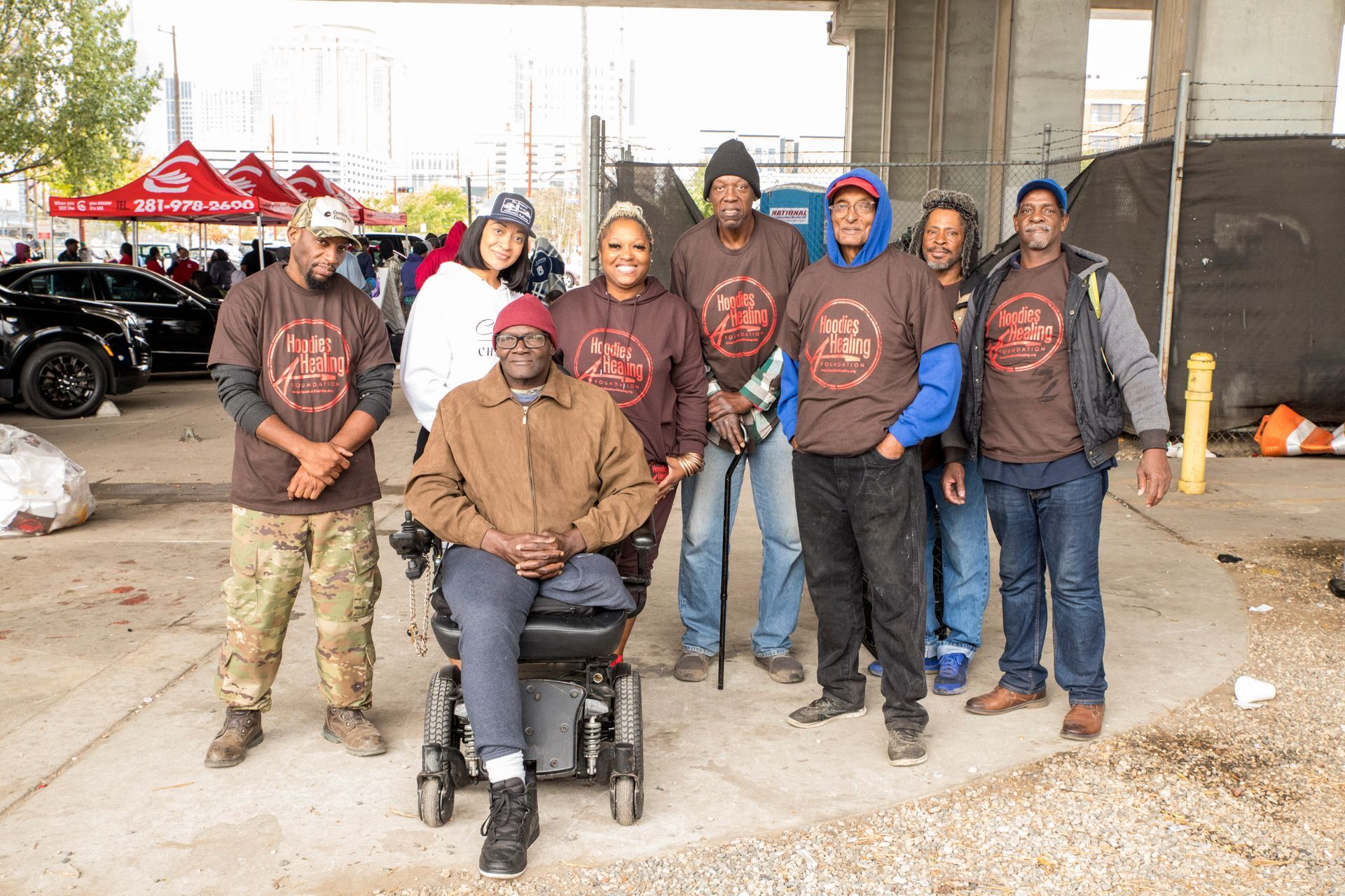 A group of people posing for a picture with one man in a wheelchair.