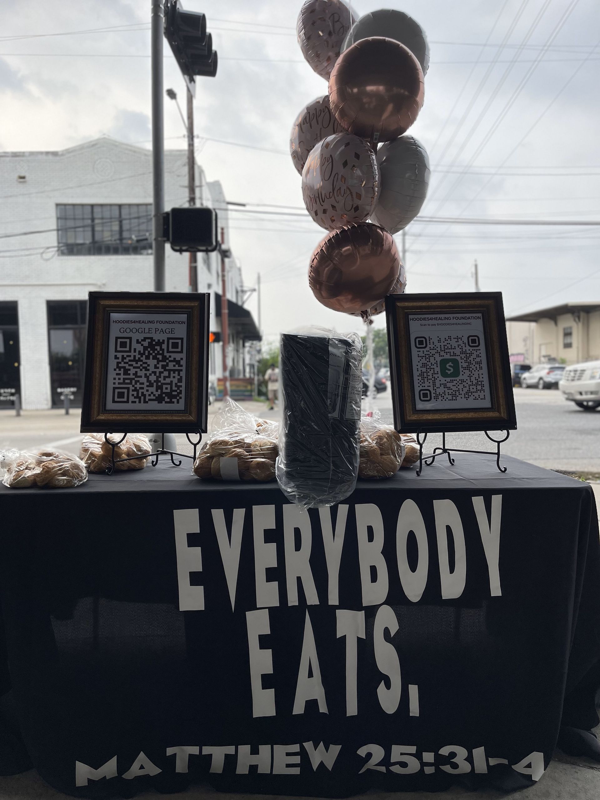 A table with balloons and a sign that says everybody eats