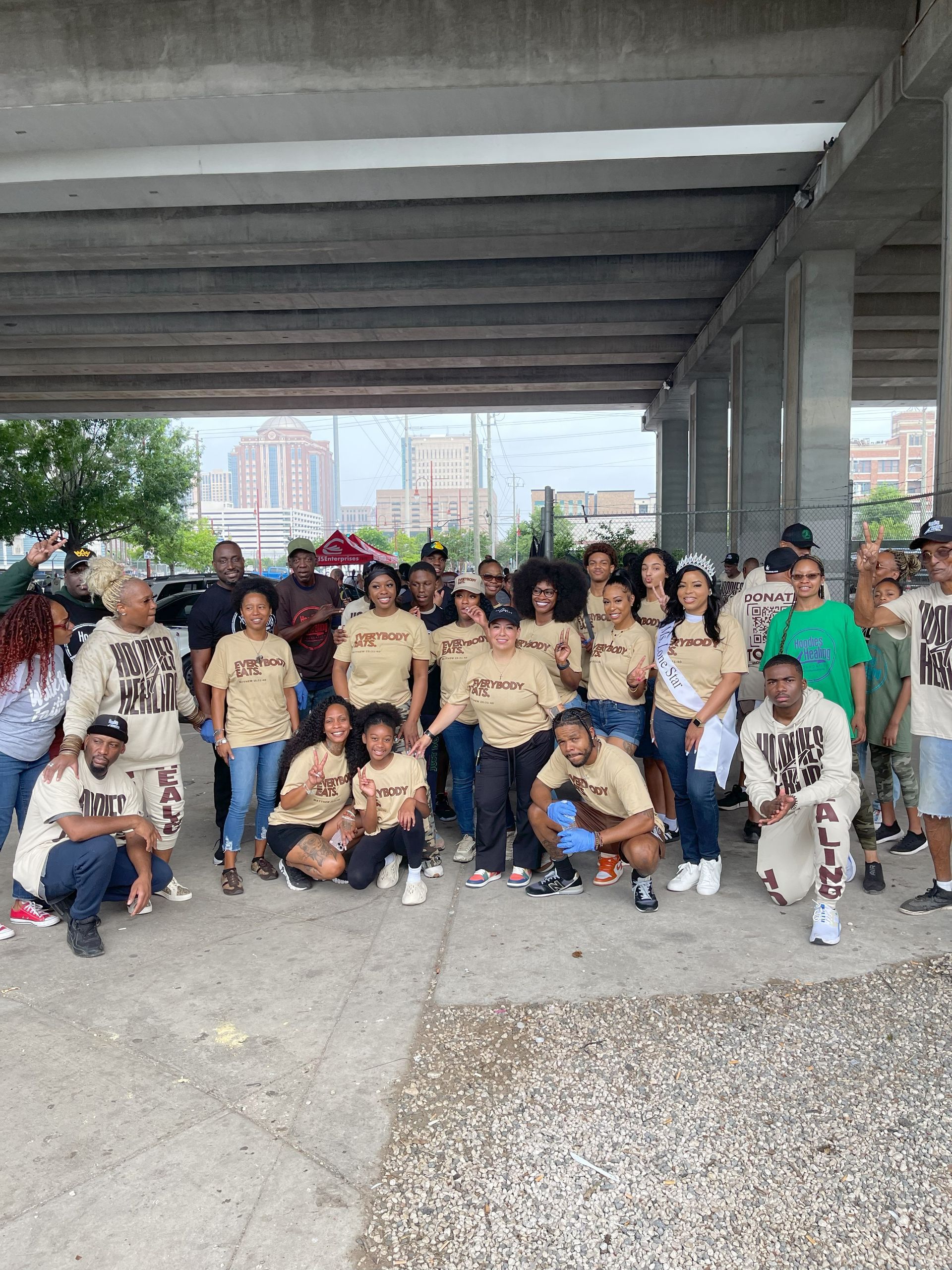 A group of people are posing for a picture under a bridge.