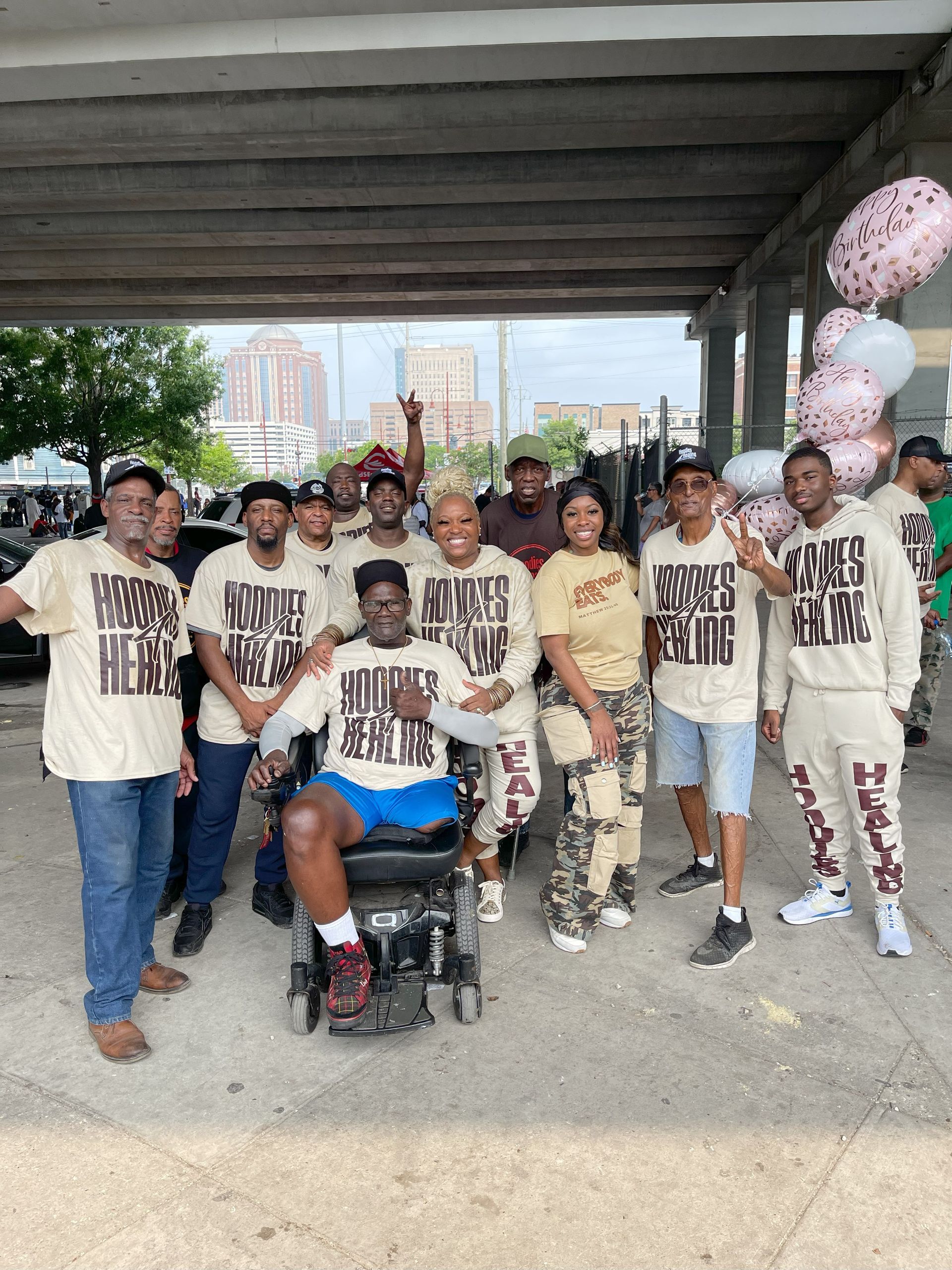 A group of people are posing for a picture with a man in a wheelchair.