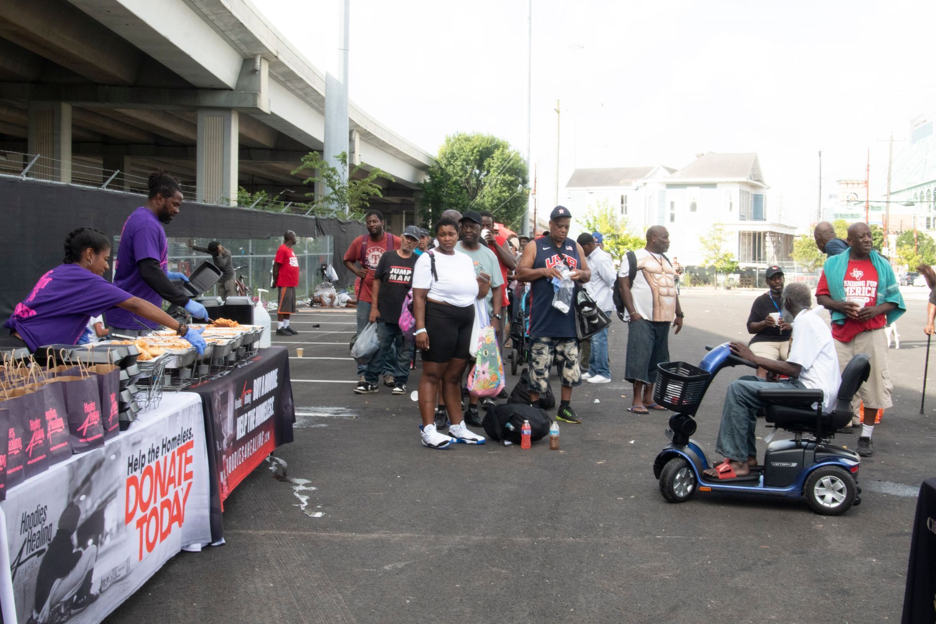 A man in a mobility scooter is standing in front of a table that says dowe today