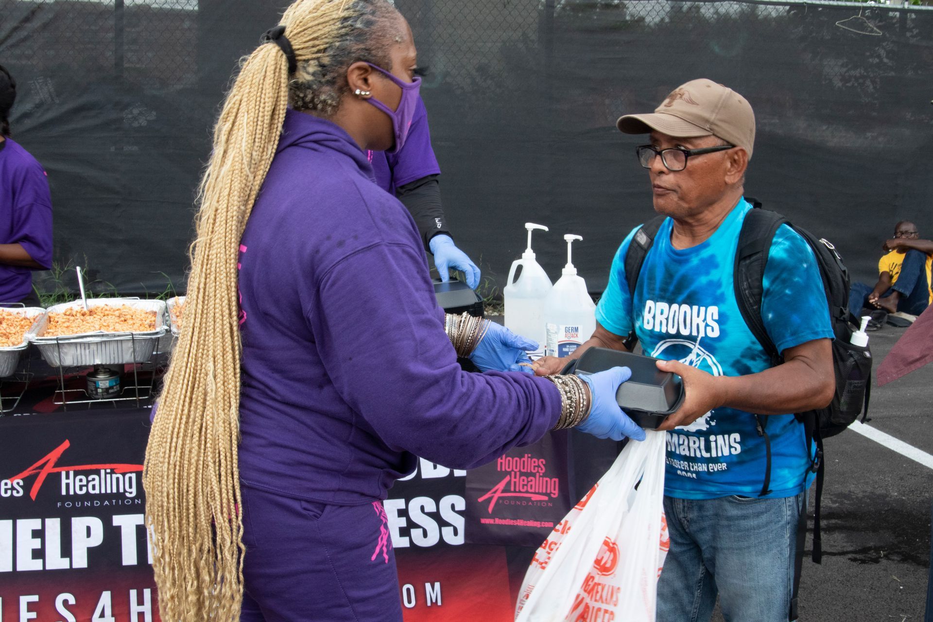 A man in a blue shirt is talking to a woman in a purple shirt