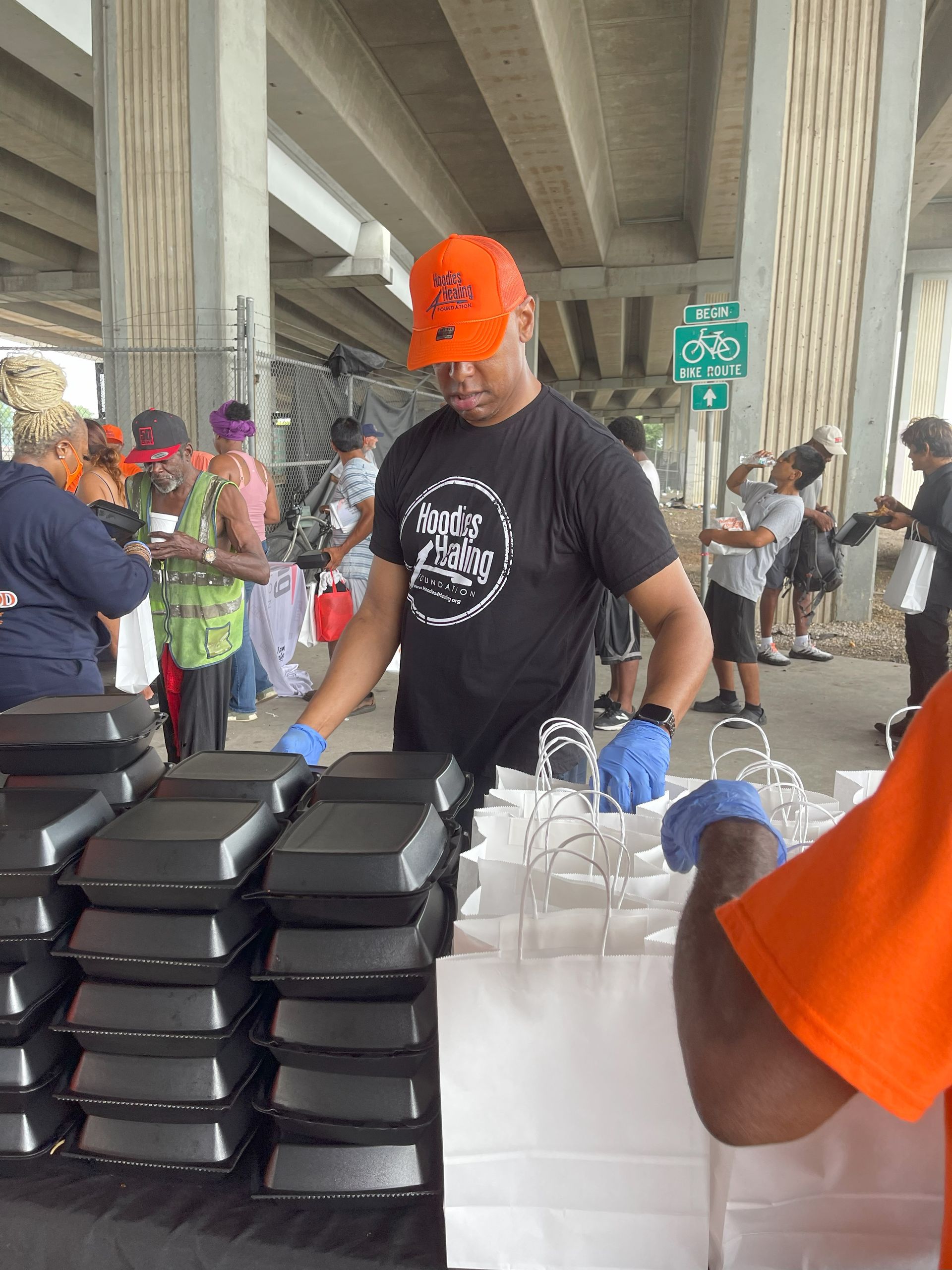 A man in an orange hat is standing in front of a stack of styrofoam containers.