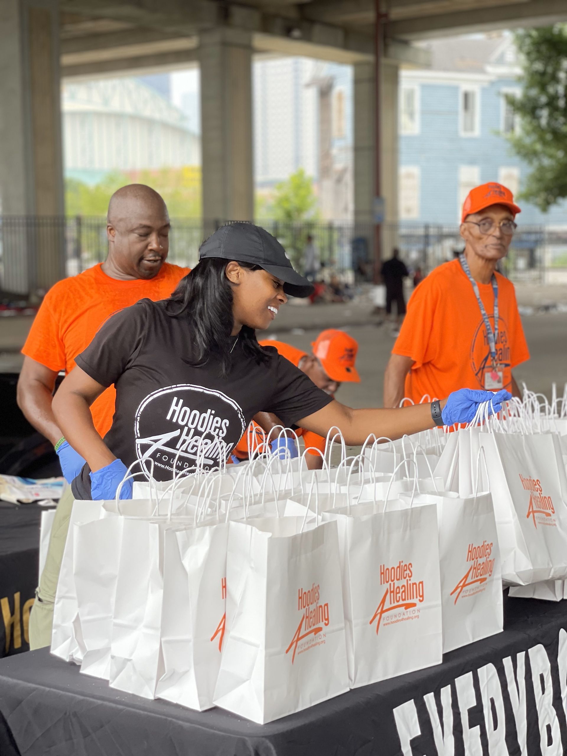 A woman is standing at a table filled with bags.