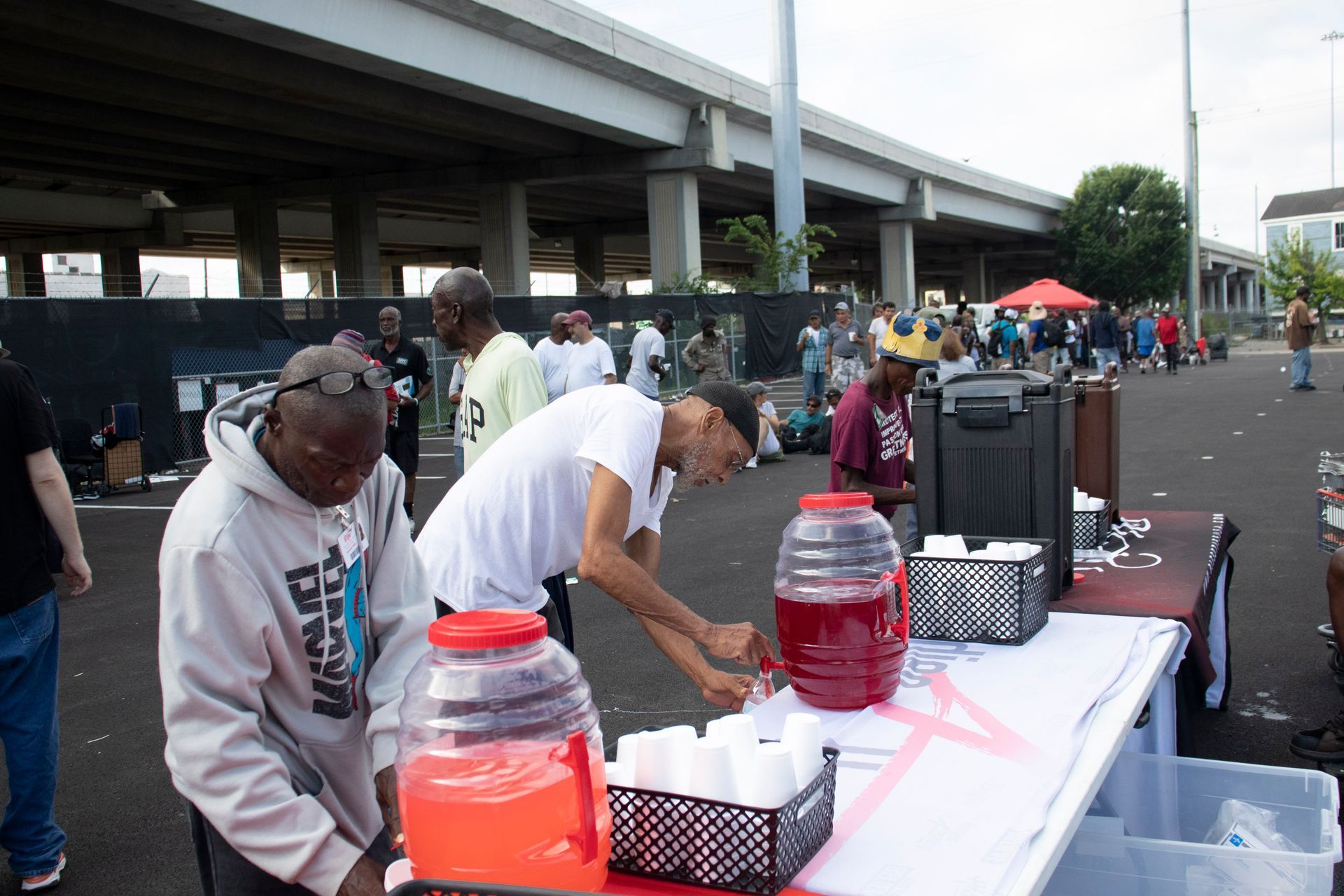 A group of people are standing around a table filled with drinks.