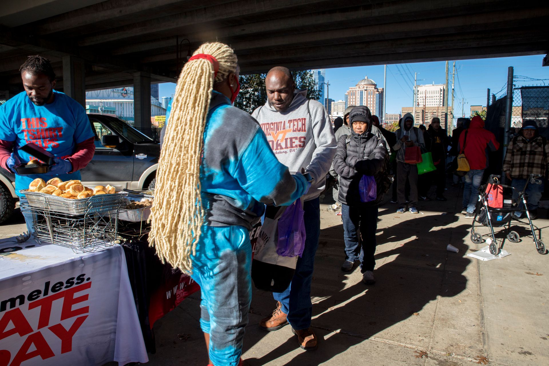 A woman with blonde braids is shaking hands with a man.