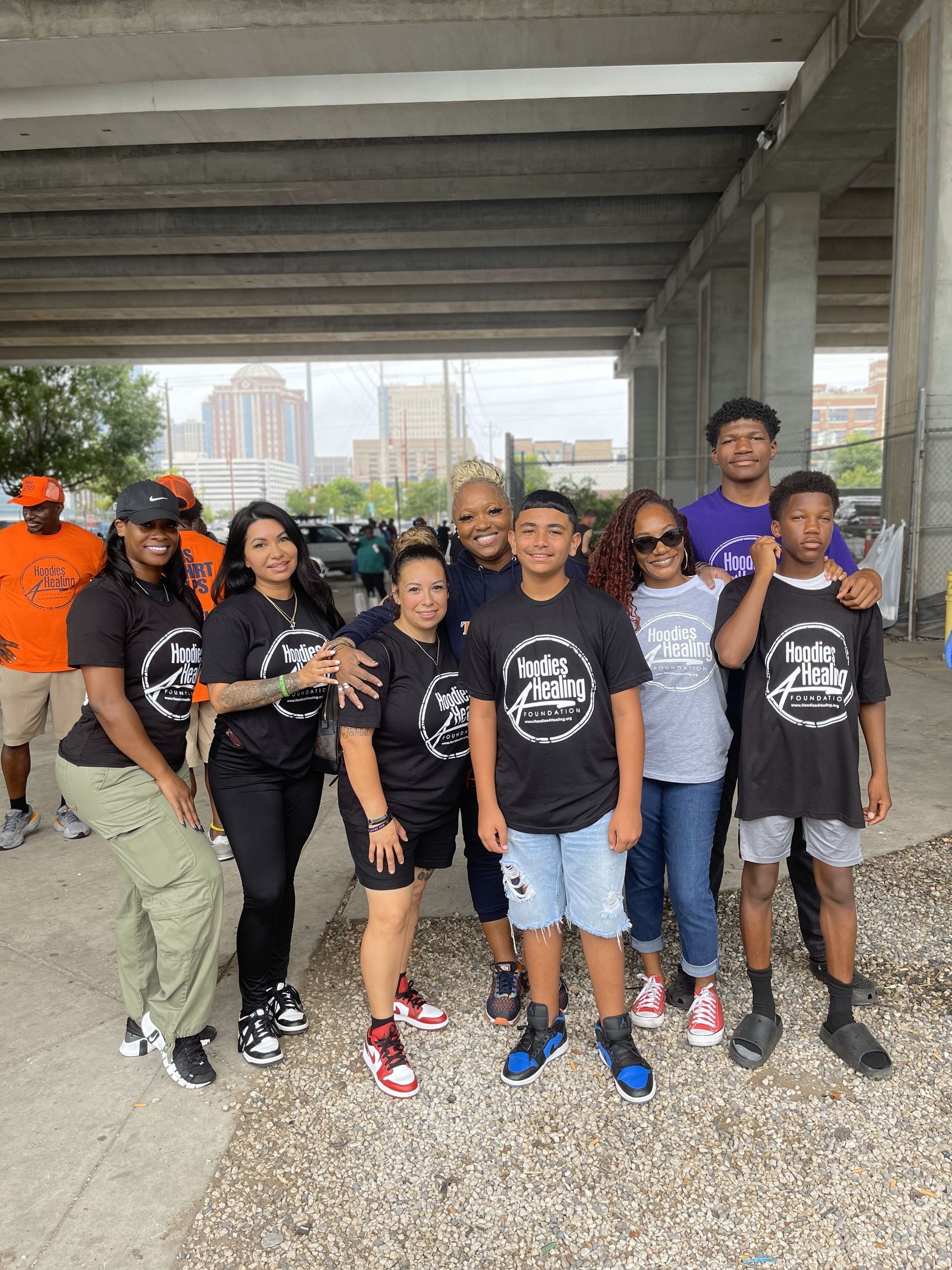 A group of people are posing for a picture under a bridge.